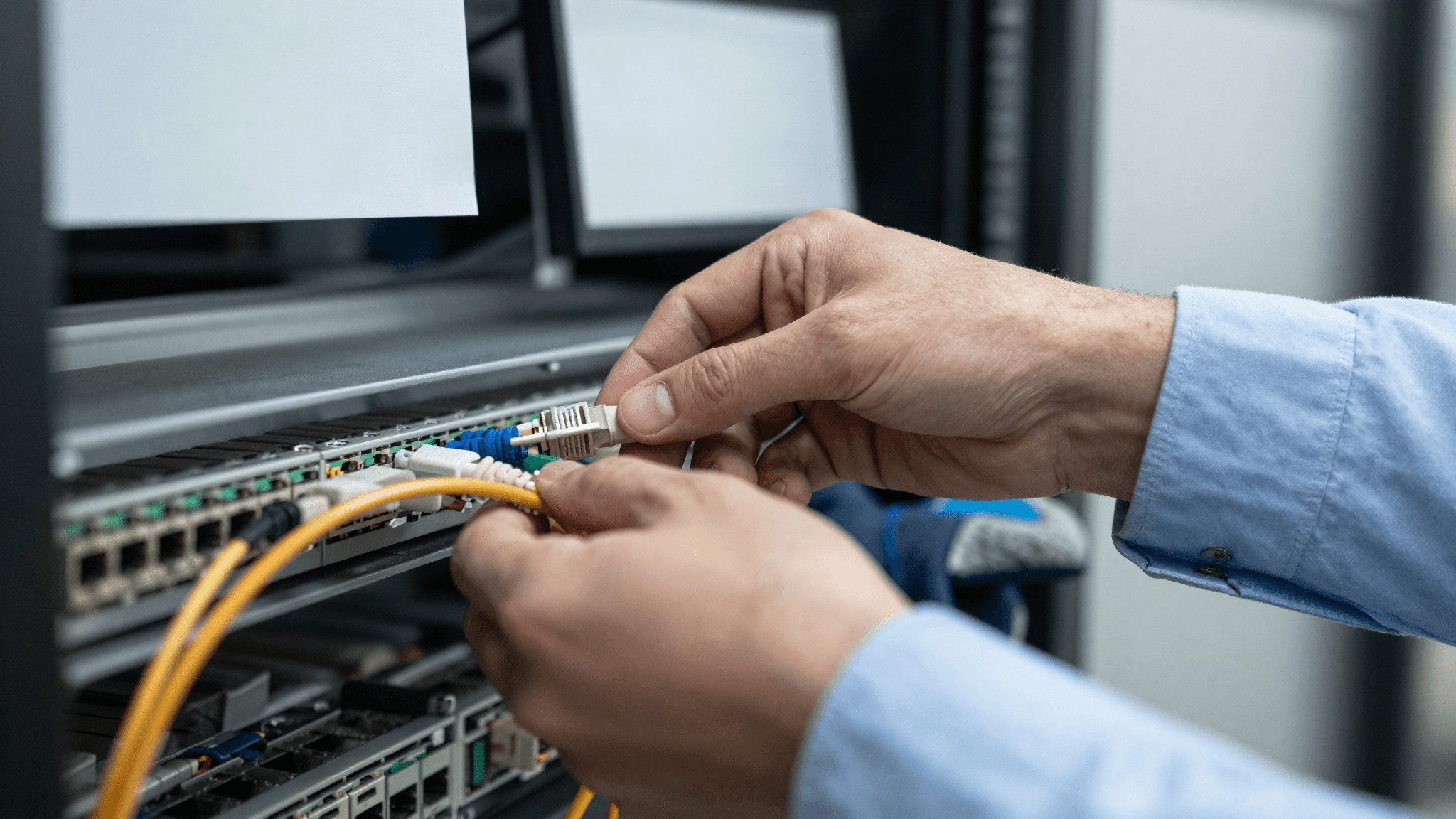 Netzwerktechniker steckt Glasfaser in Patch-Panel (KI-generiert)