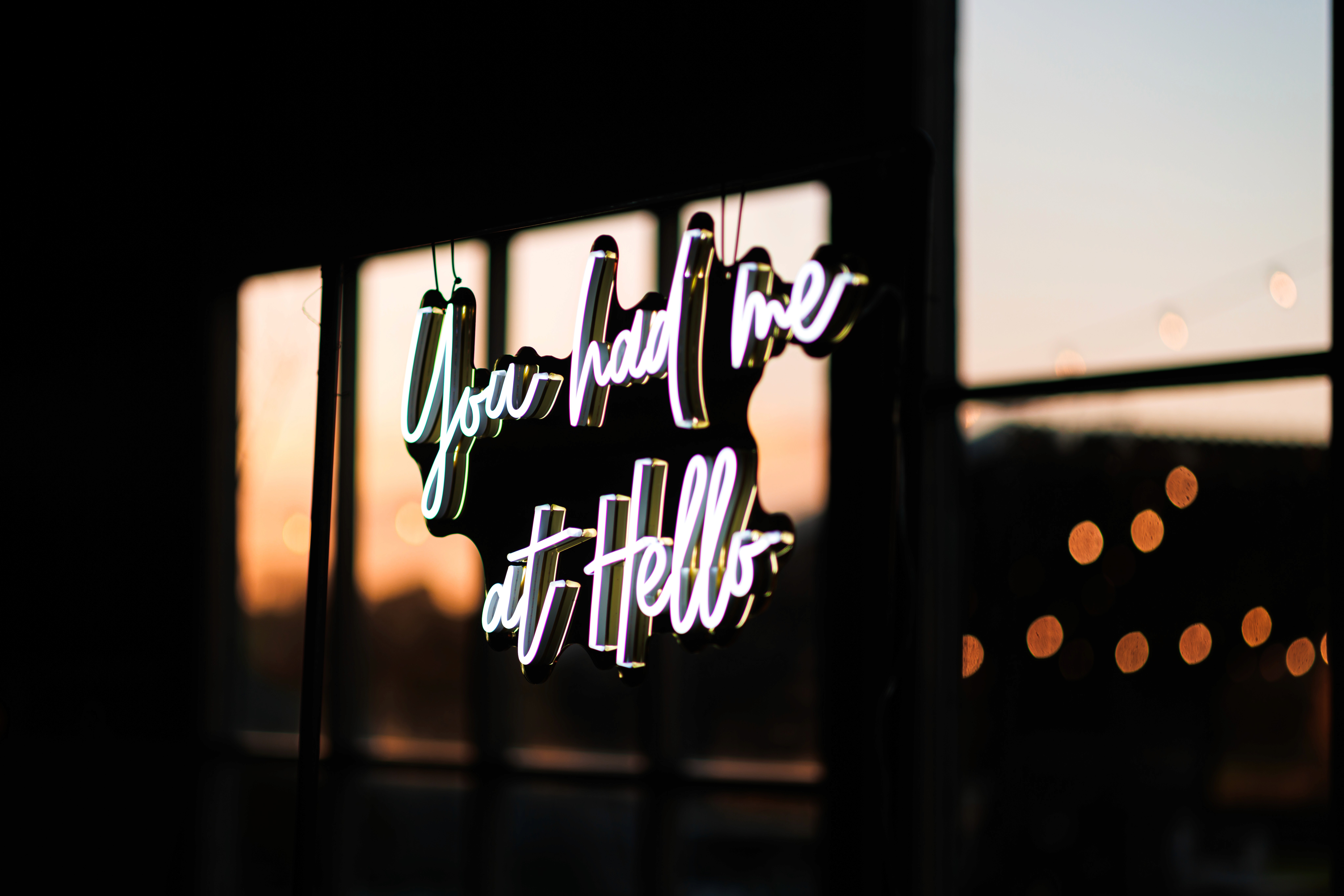 The You Had Me at Hello wedding sign with warm bulbs in the background