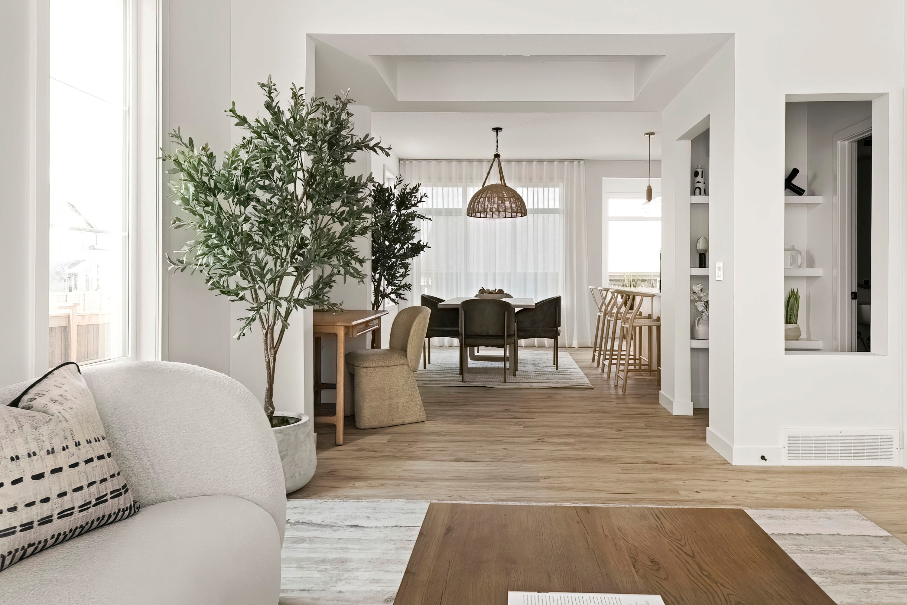 Zen Luxury Staging entry with live-edge console, potted olive tree and view to the dining room, staged by HAUS Interiors, Heartwood, Calgary