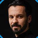a man with a goatee smiles at the camera