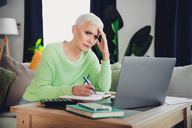 individual reviewing investment accounts on laptop looking overwhelmed by financial decisions