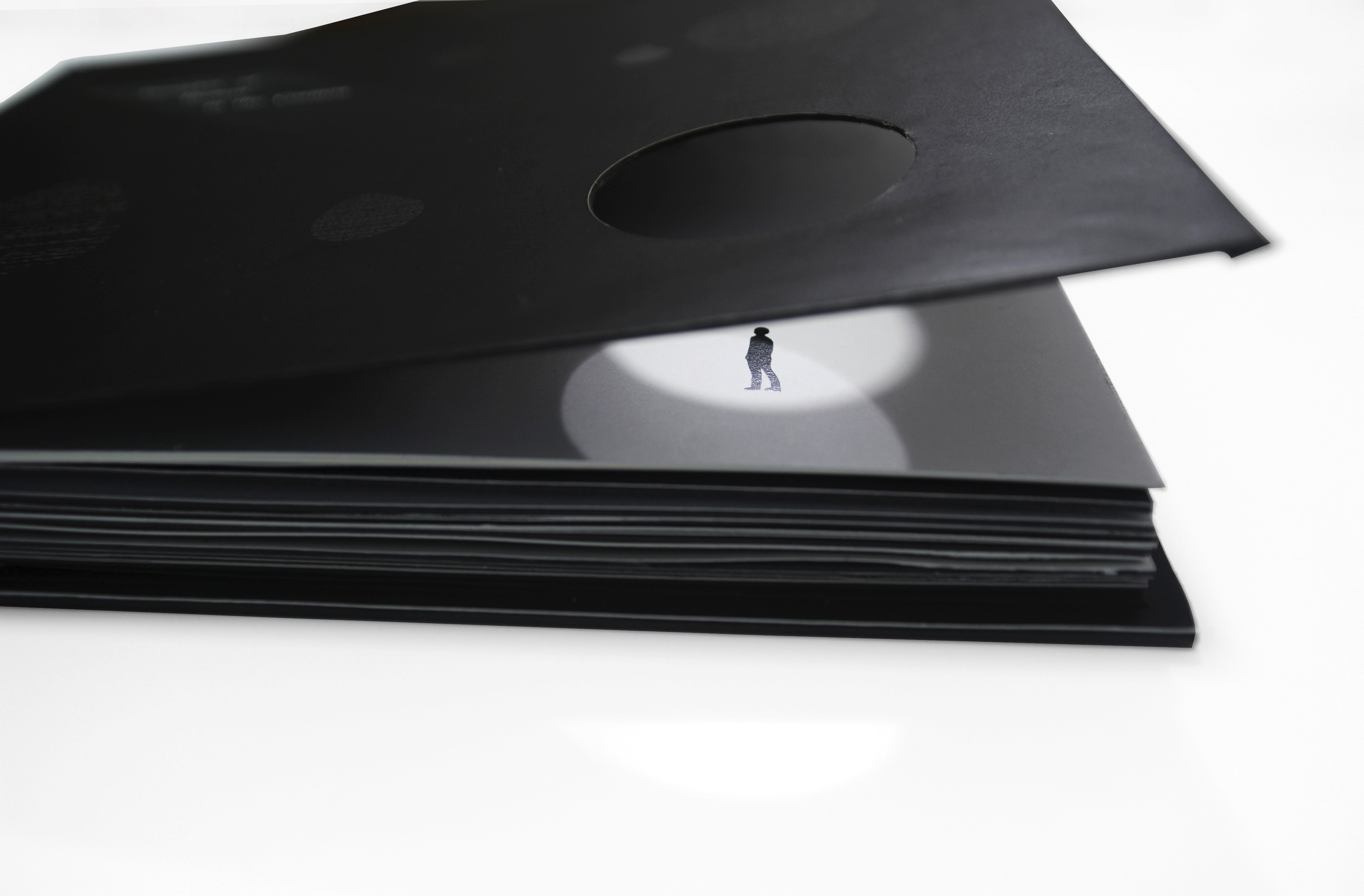 A black covered book and on the first page a picture of a person in a white circle.