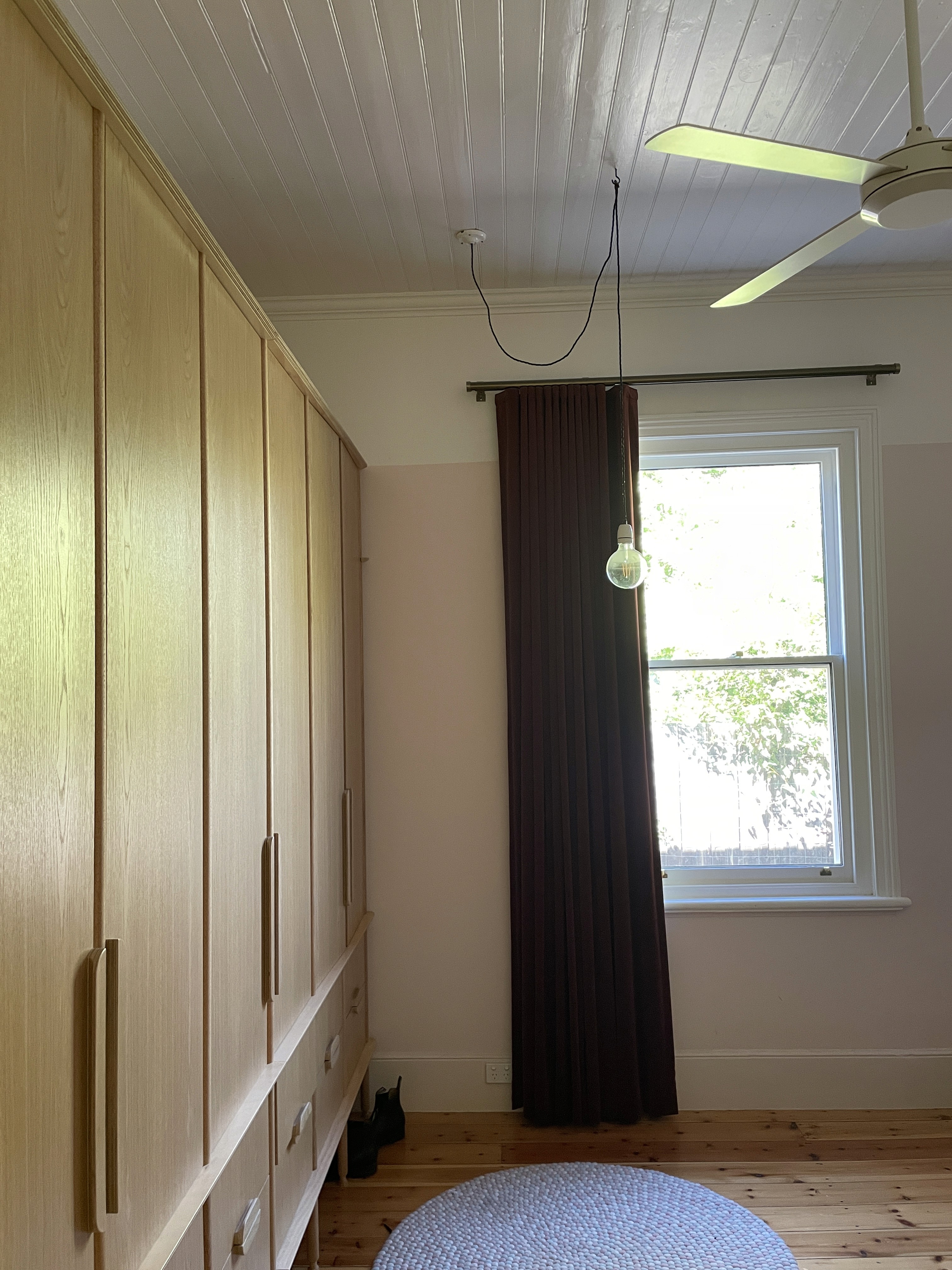 Bedroom wardrobe with fan and curtains