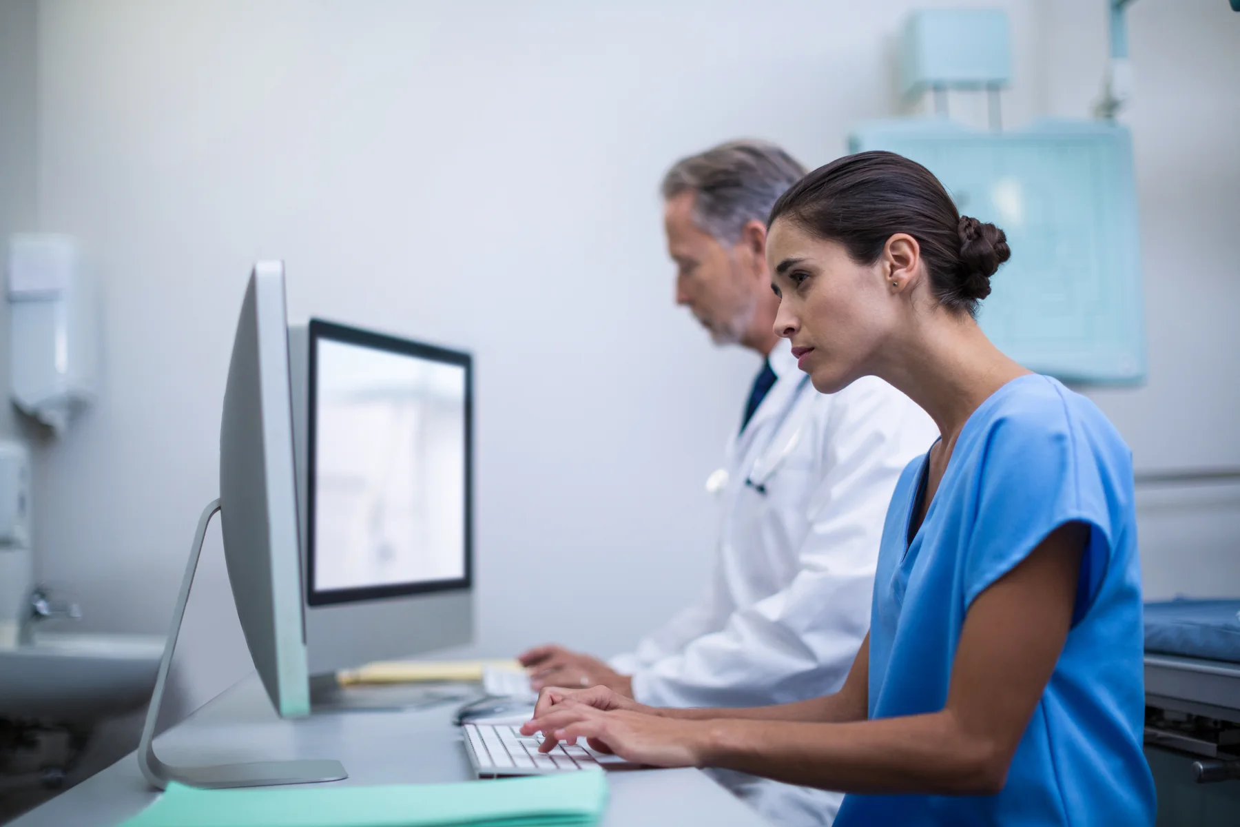 Medical Professionals Working Together at Computer in Hospital