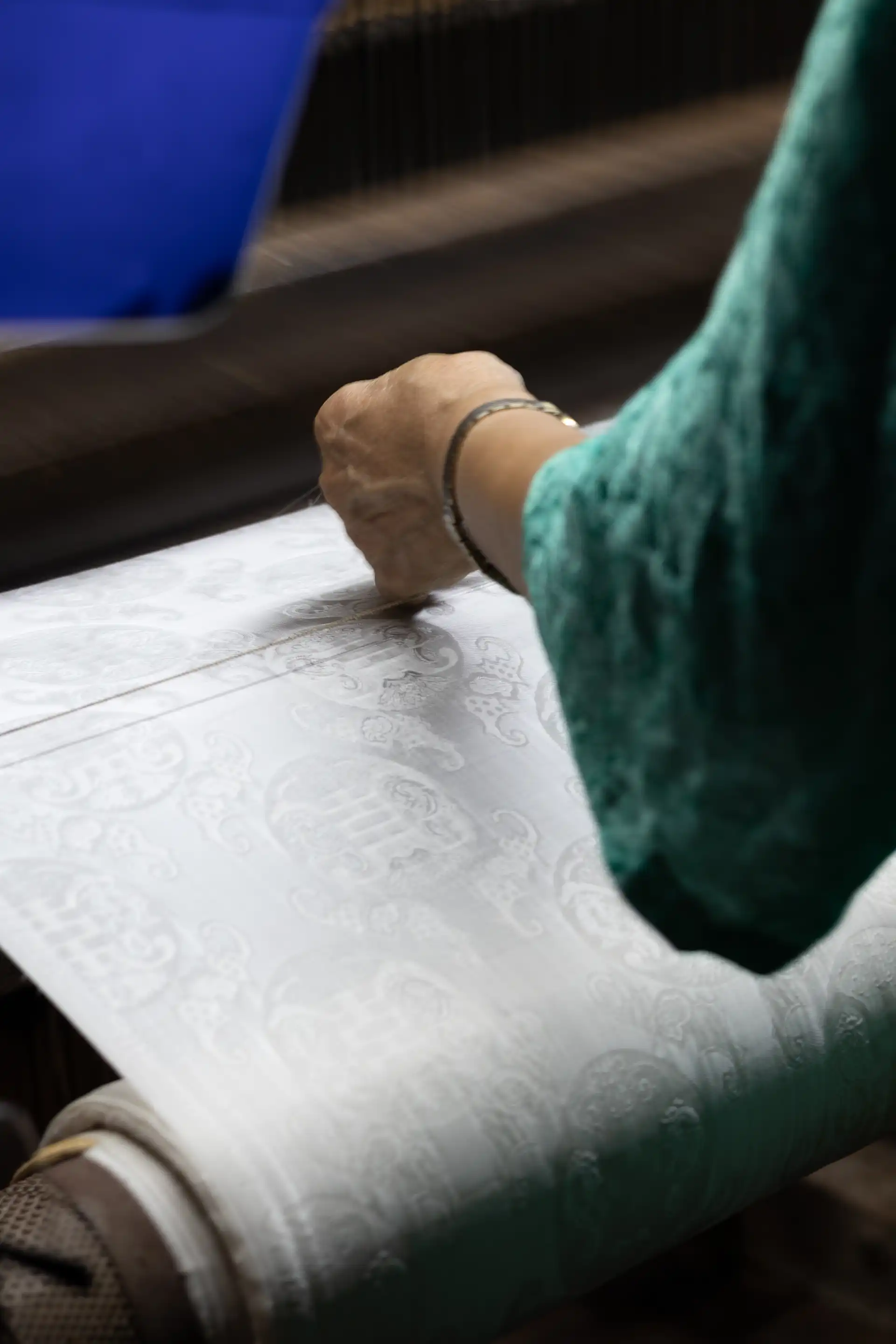 Women weaving a fabric with a pattern from silk