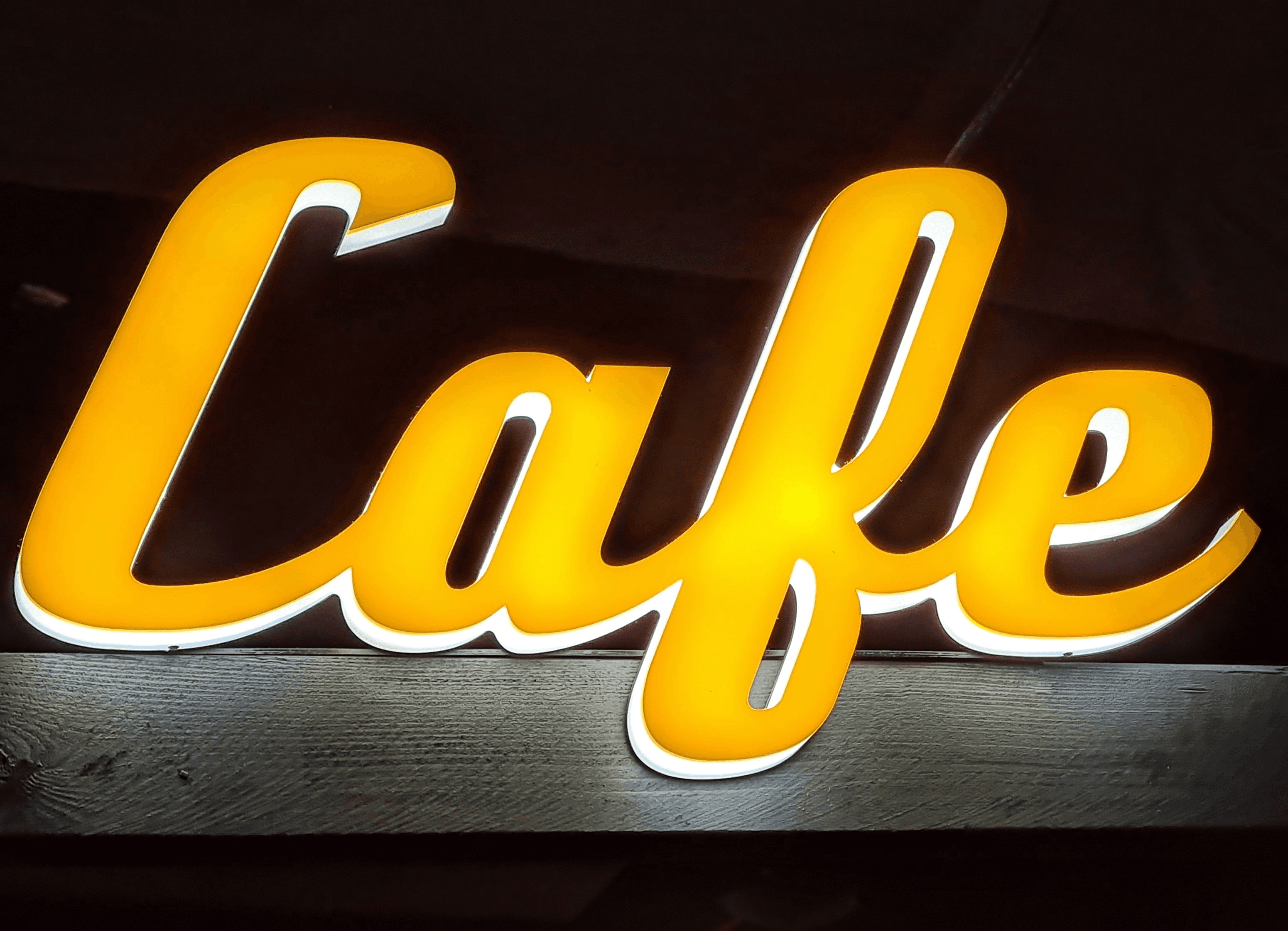 Leuchtende Lichtwerbung an einem Gebäude, LED-Schilder und Neonlogos strahlen in der Nacht