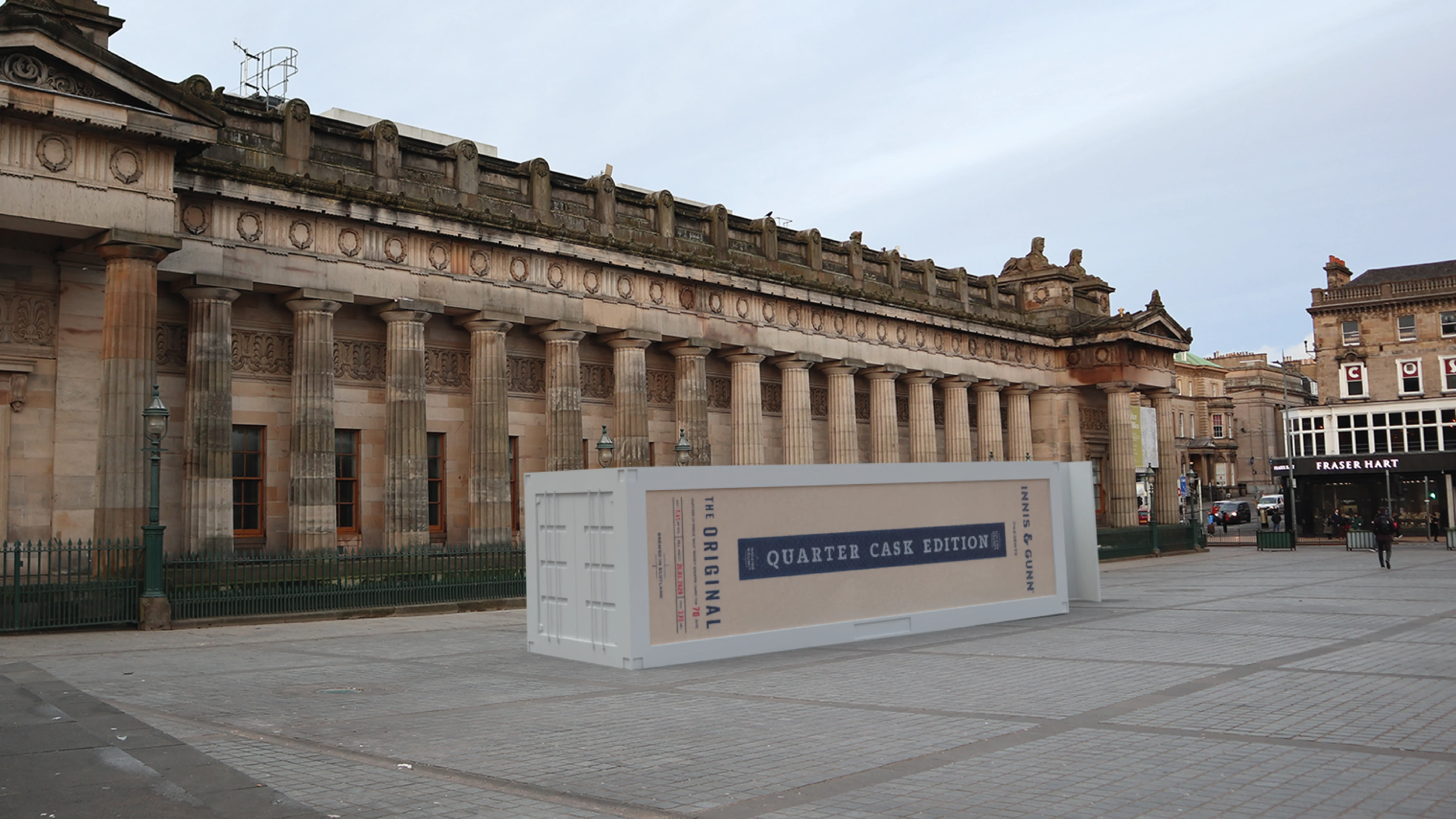 Shipping container sitting in the middle of a walkway, decaled to look like packaging