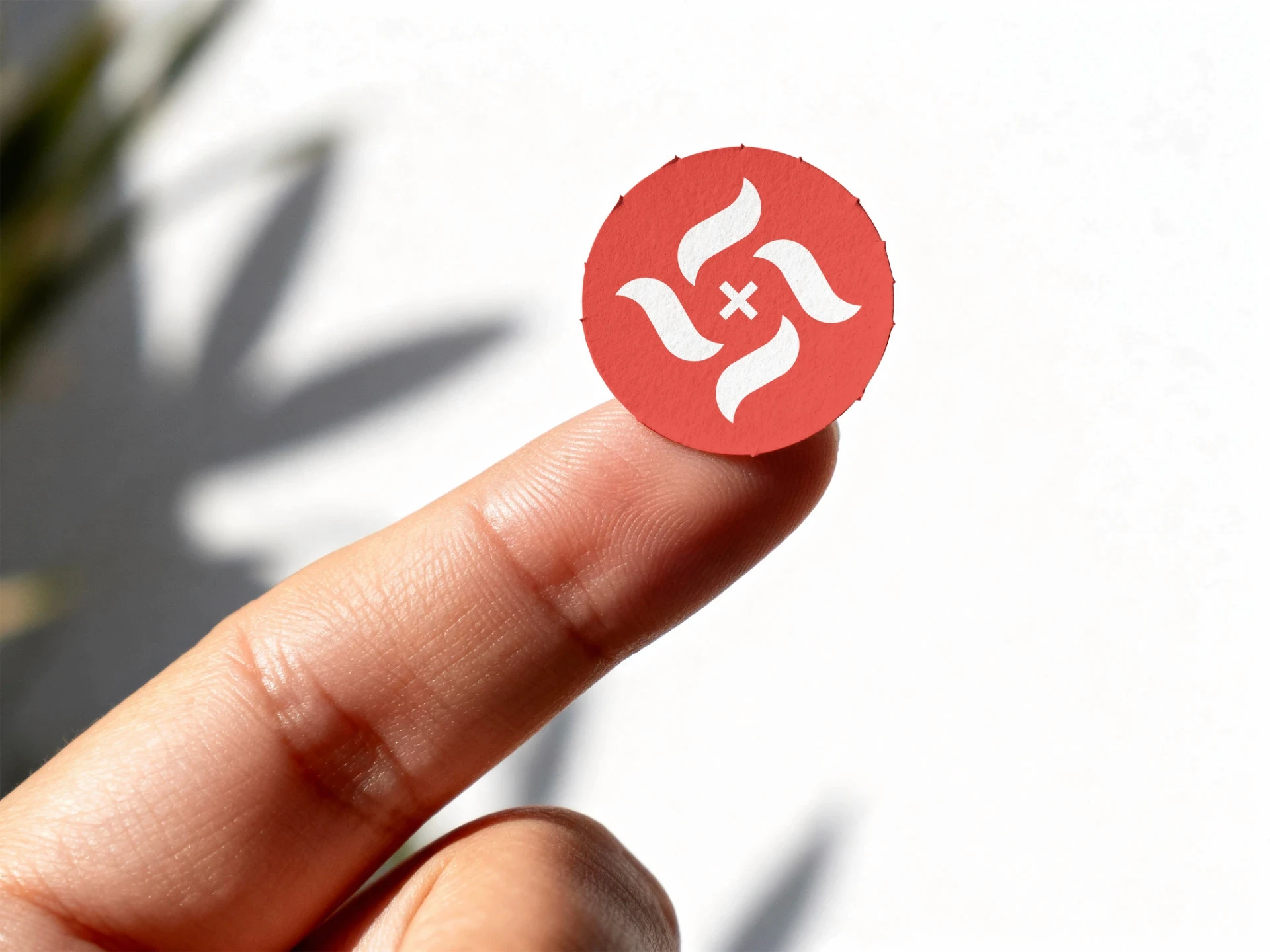 Finger holds red logo. Logo design Barcelona by a freelance brand identity designer.
