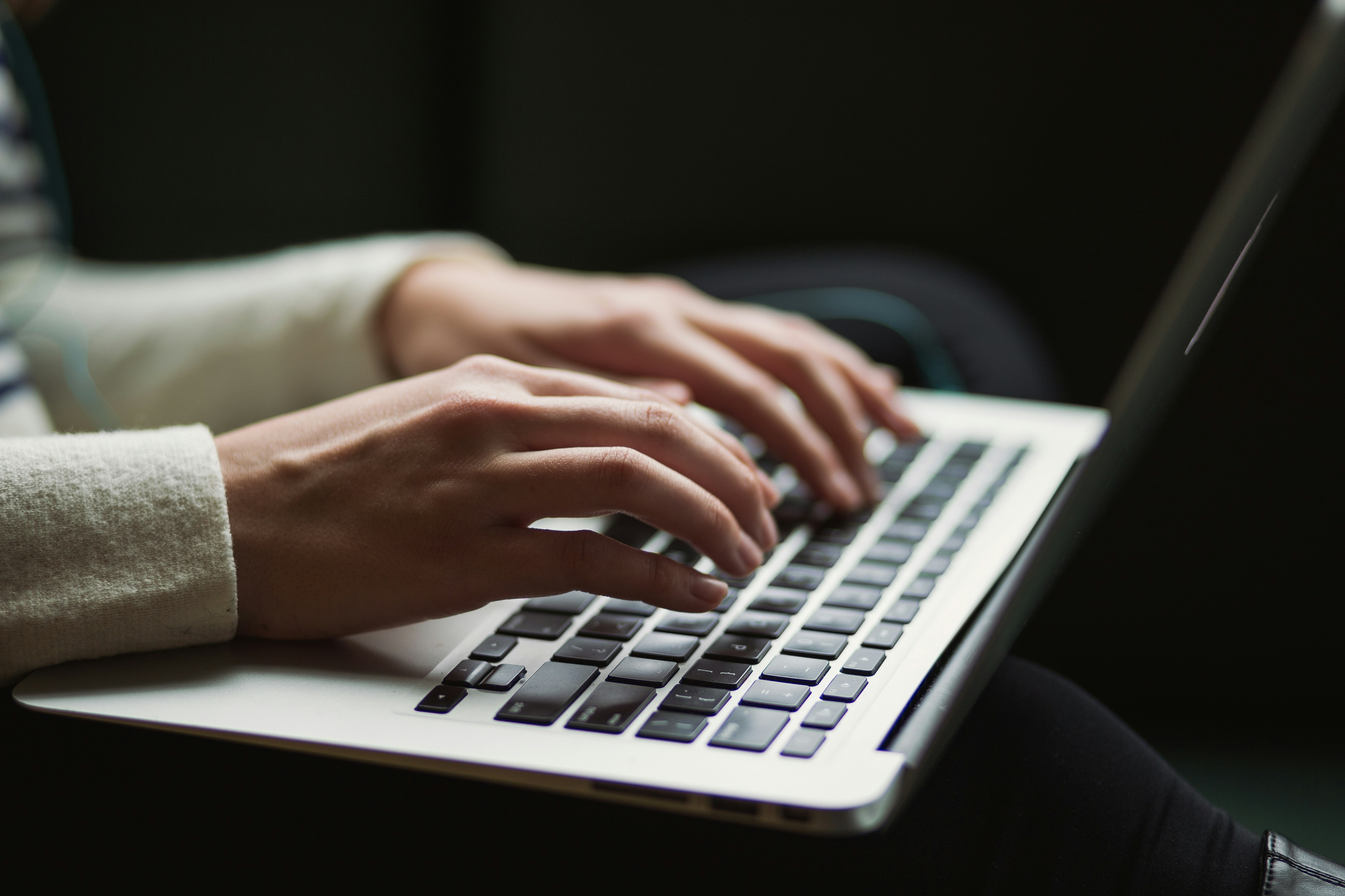 Person writing Descriptive Essay on Laptop