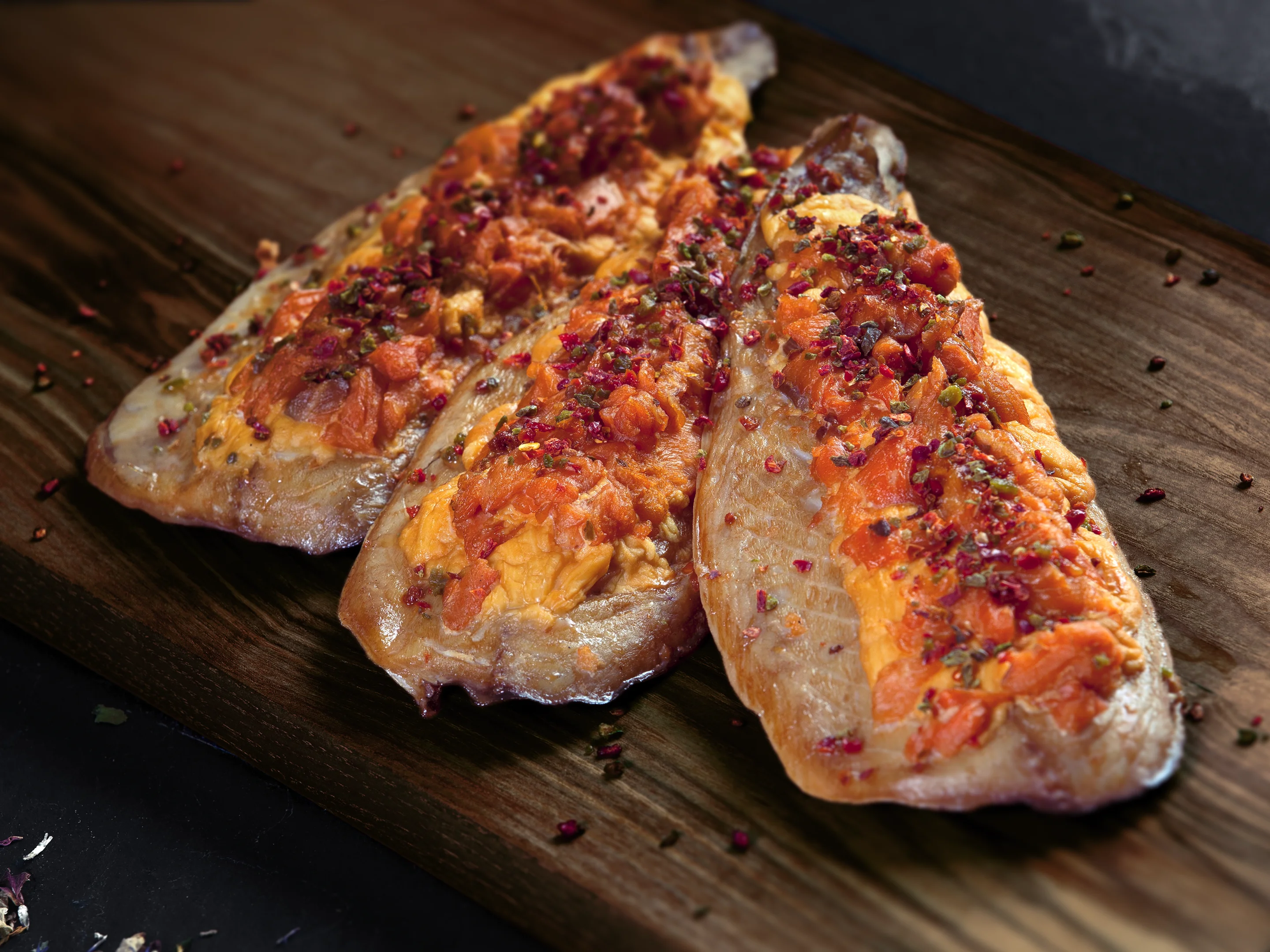 Geräucherte Makrelenfilets mit würziger Gewürzkruste auf rustikalem Holzbrett