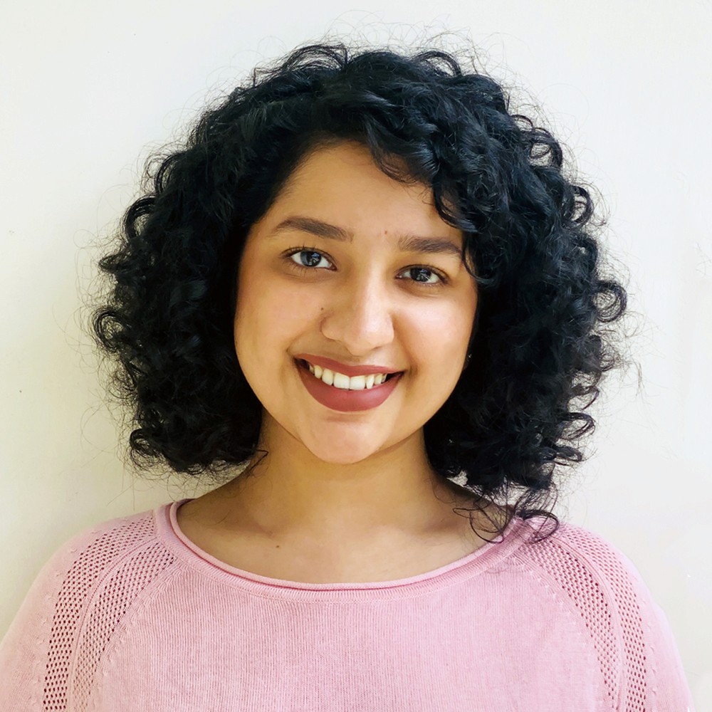 Indian Woman with curly hair and prink shirt
