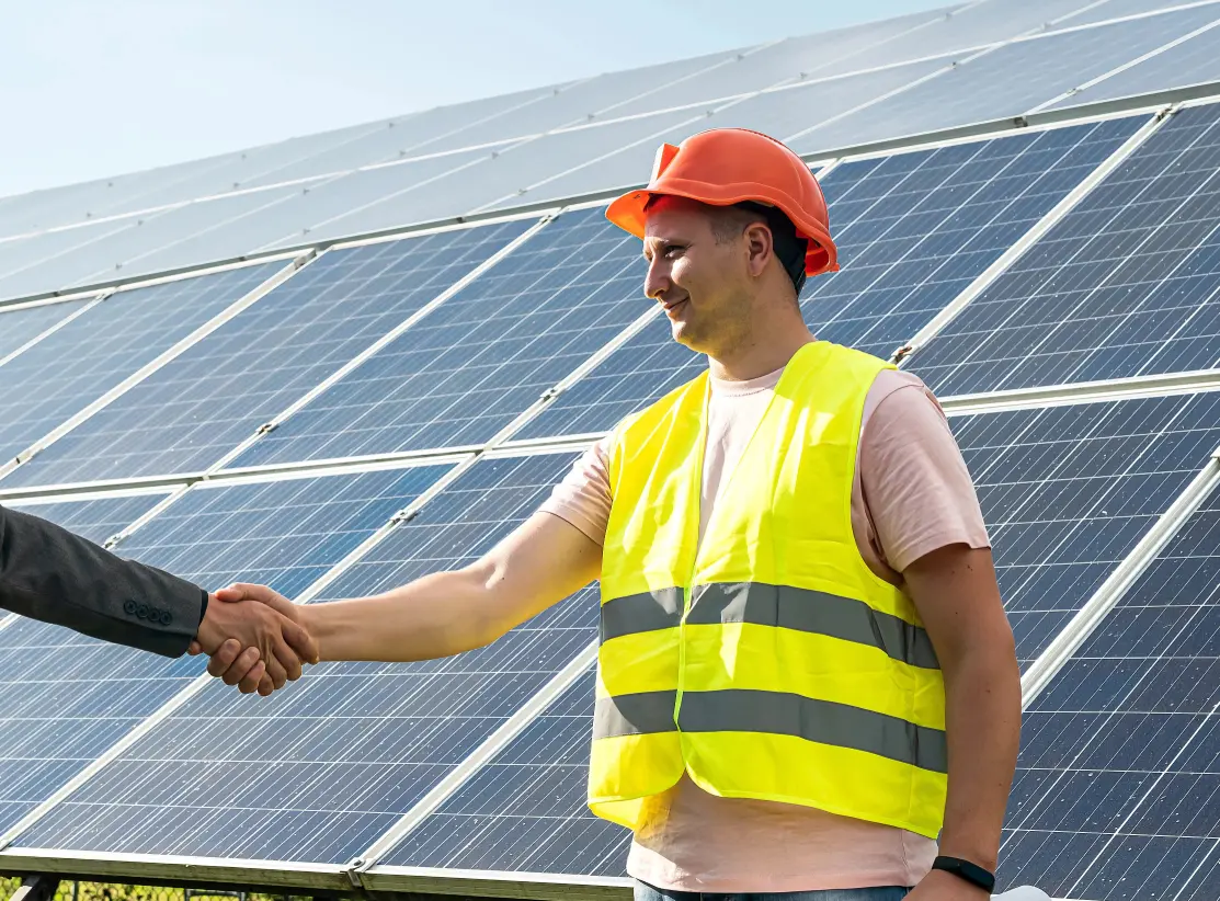 Tehnician SpalPanouri strângând mâna unui client în fața panourilor fotovoltaice curate