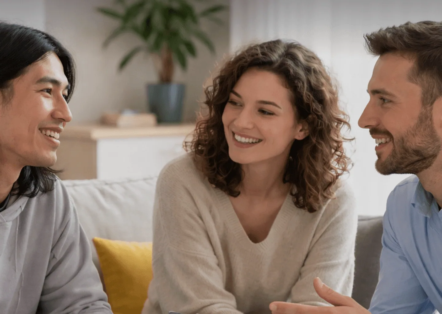Three people in conversation on a sofa during a friendly consultation