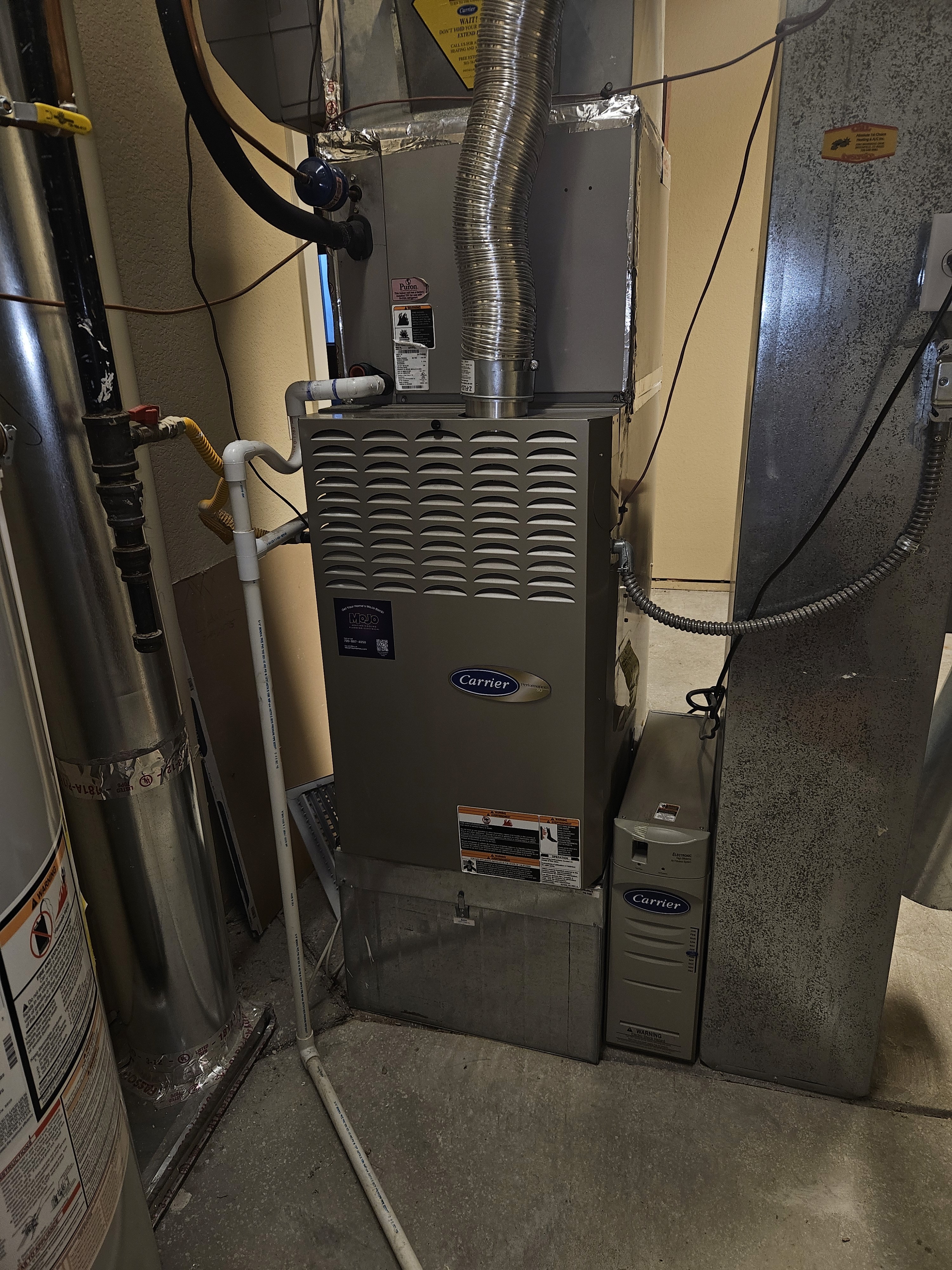 The image shows a Carrier brand furnace unit, which is part of a home's heating, ventilation, and air conditioning (HVAC) system. 