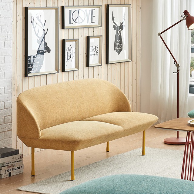 Modern mustard yellow loveseat in a Nordic-style living room. Featuring a gallery wall with black and white prints, wood paneling, and mid-century modern furniture accents. Ideal for small space living room inspiration and contemporary apartment decor.