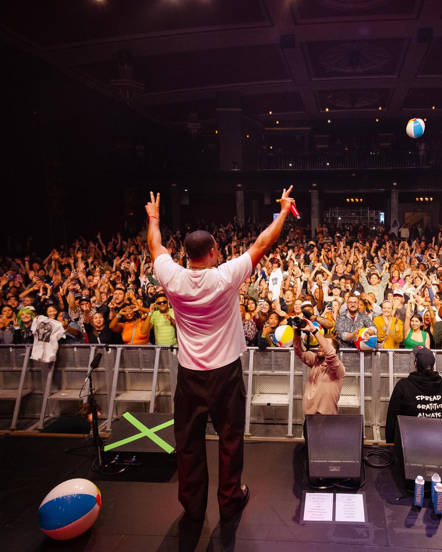 alt="will smith raising his arms to a cheering crowd"