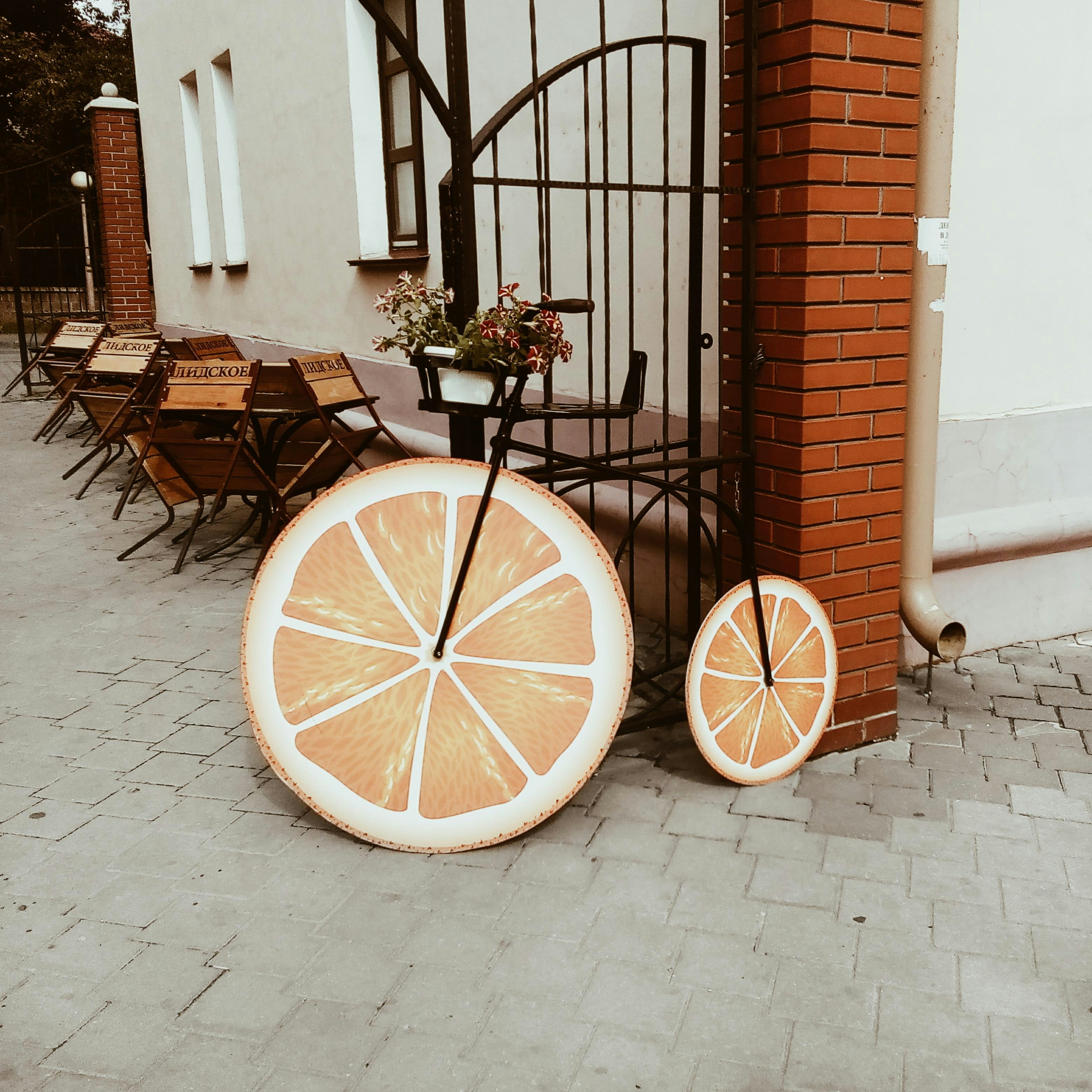 Bicycle decorated with orange slices on pavement