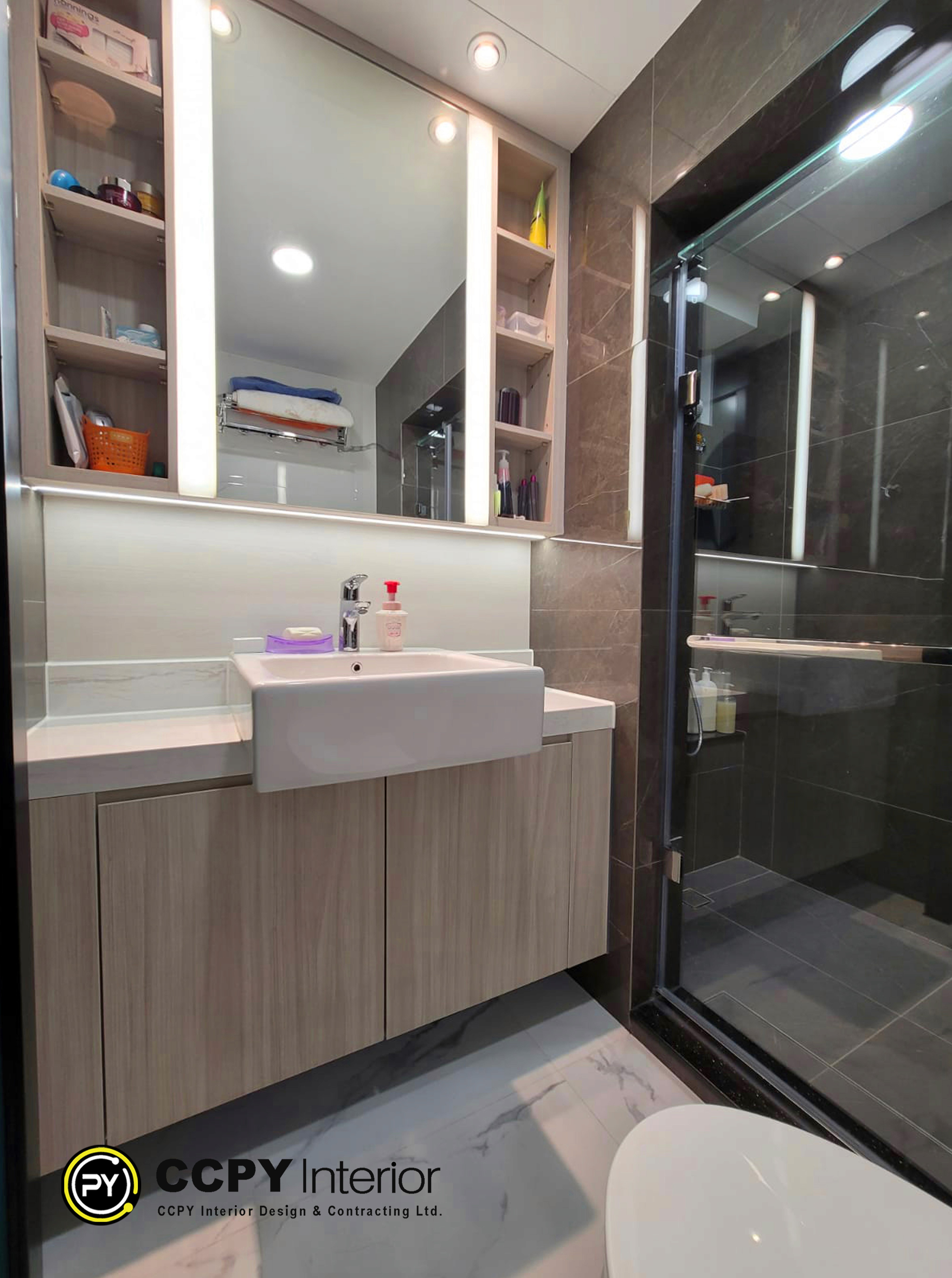 This bathroom features modern, functional design elements tailored for urban living:Floating Vanity: A sleek, light wood grain cabinet is mounted off the floor, making the space feel larger and easier to clean.Integrated Storage: The setup includes a mirror cabinet with built-in LED lighting, providing both functionality and hidden storage for toiletries.Compact Fixtures: A semi-recessed basin maximizes counter space while maintaining a contemporary aesthetic.