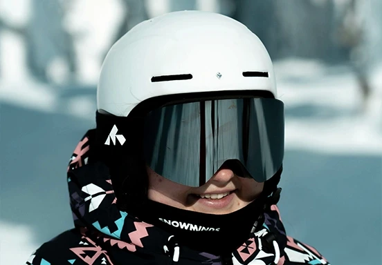 Femme avec casque de ski blanc