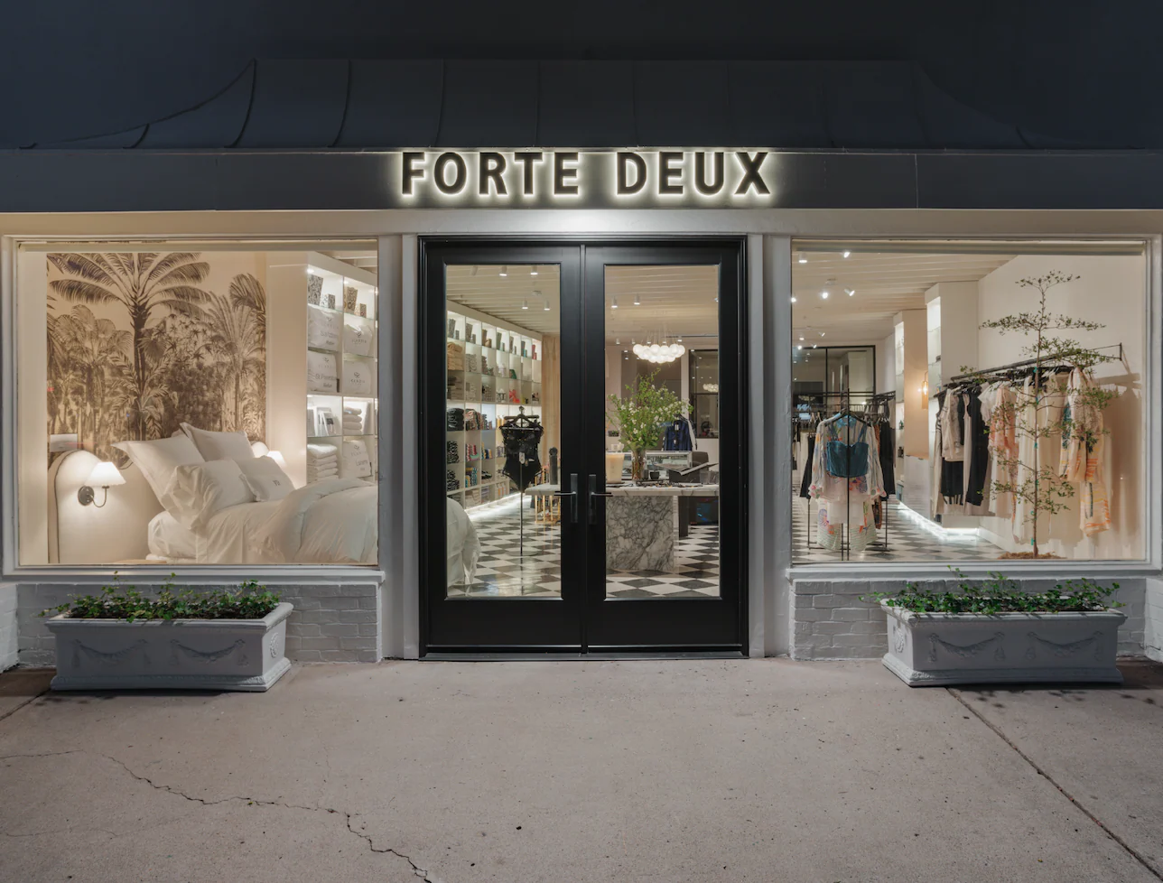Forte Deux fashion boutique storefront at night featuring custom backlit exterior signage and illuminated retail window displays.