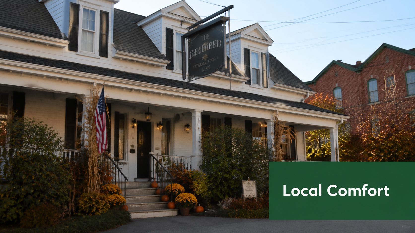 The historic Woodlynn Hills Inn decorated for autumn with pumpkins and an American flag on the front porch.