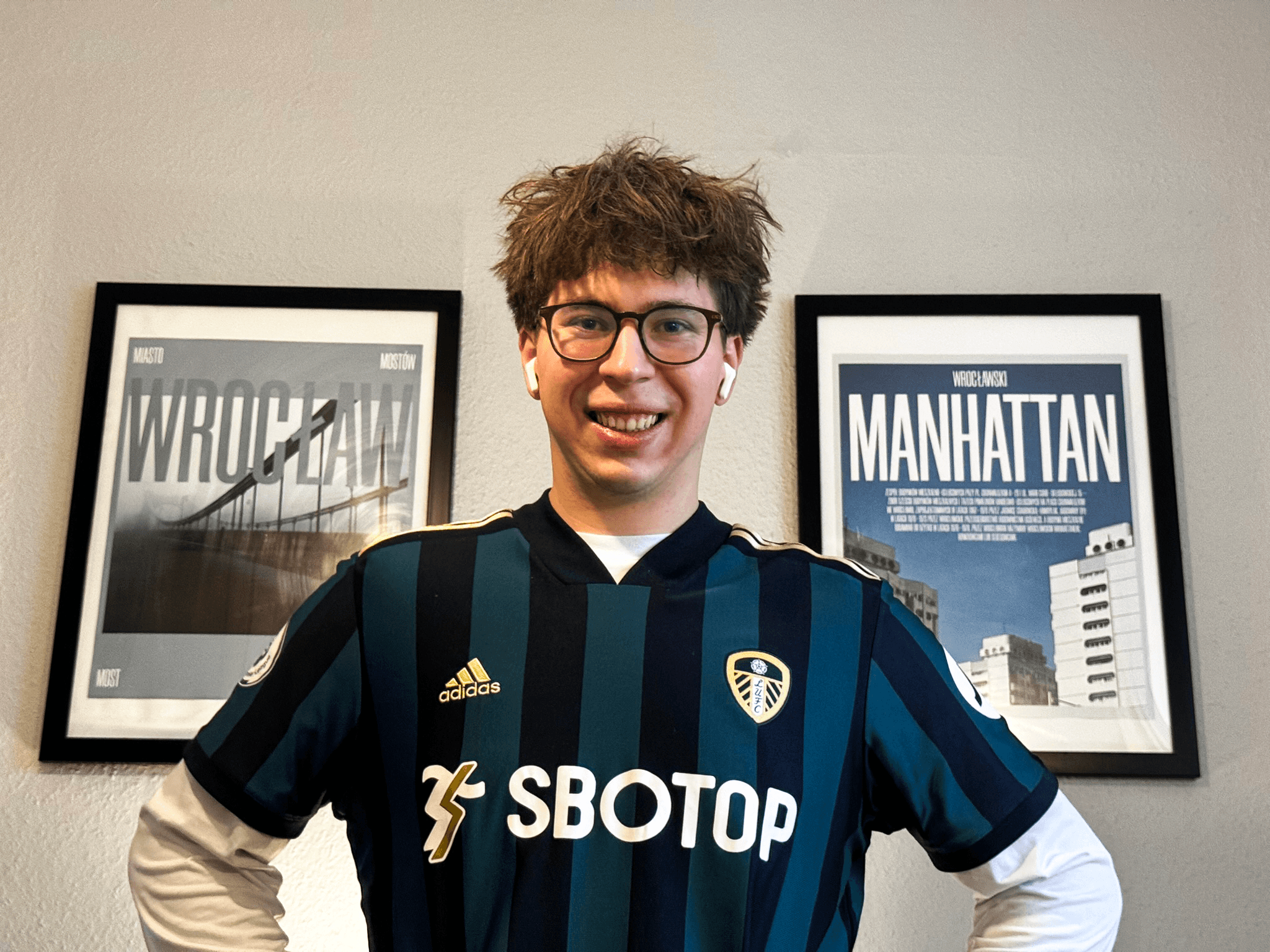 zdjęcie przedstawiające projektanta, który siedzi uśmiechnięty przy swoim stanowisku