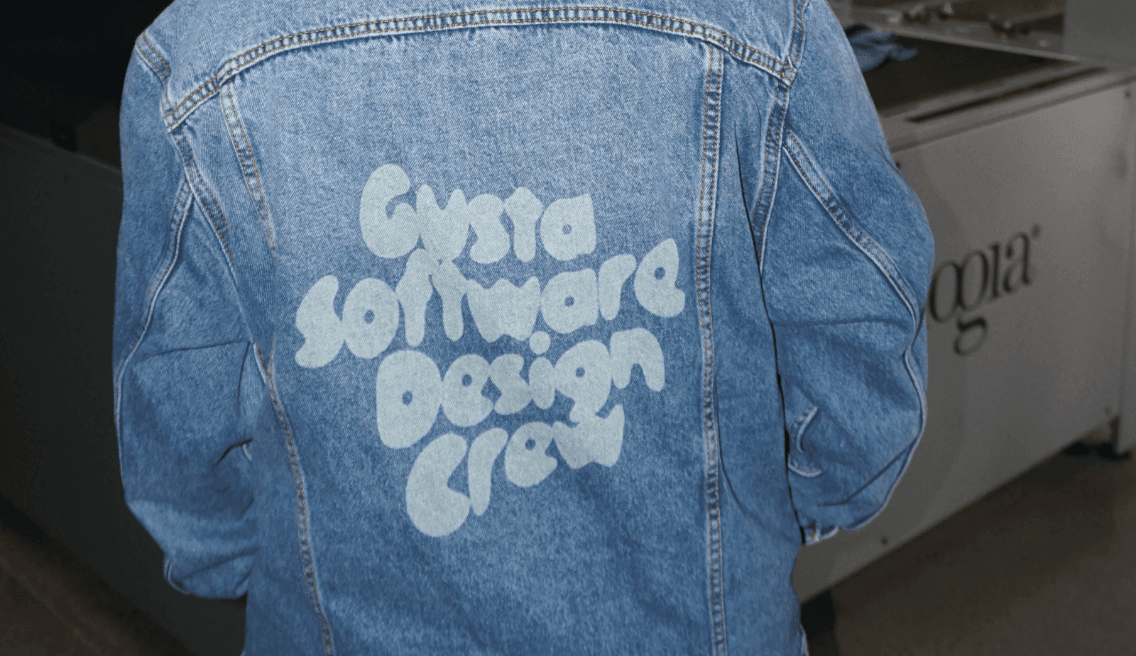 Someone wearing a denim jacket with custom design on the back