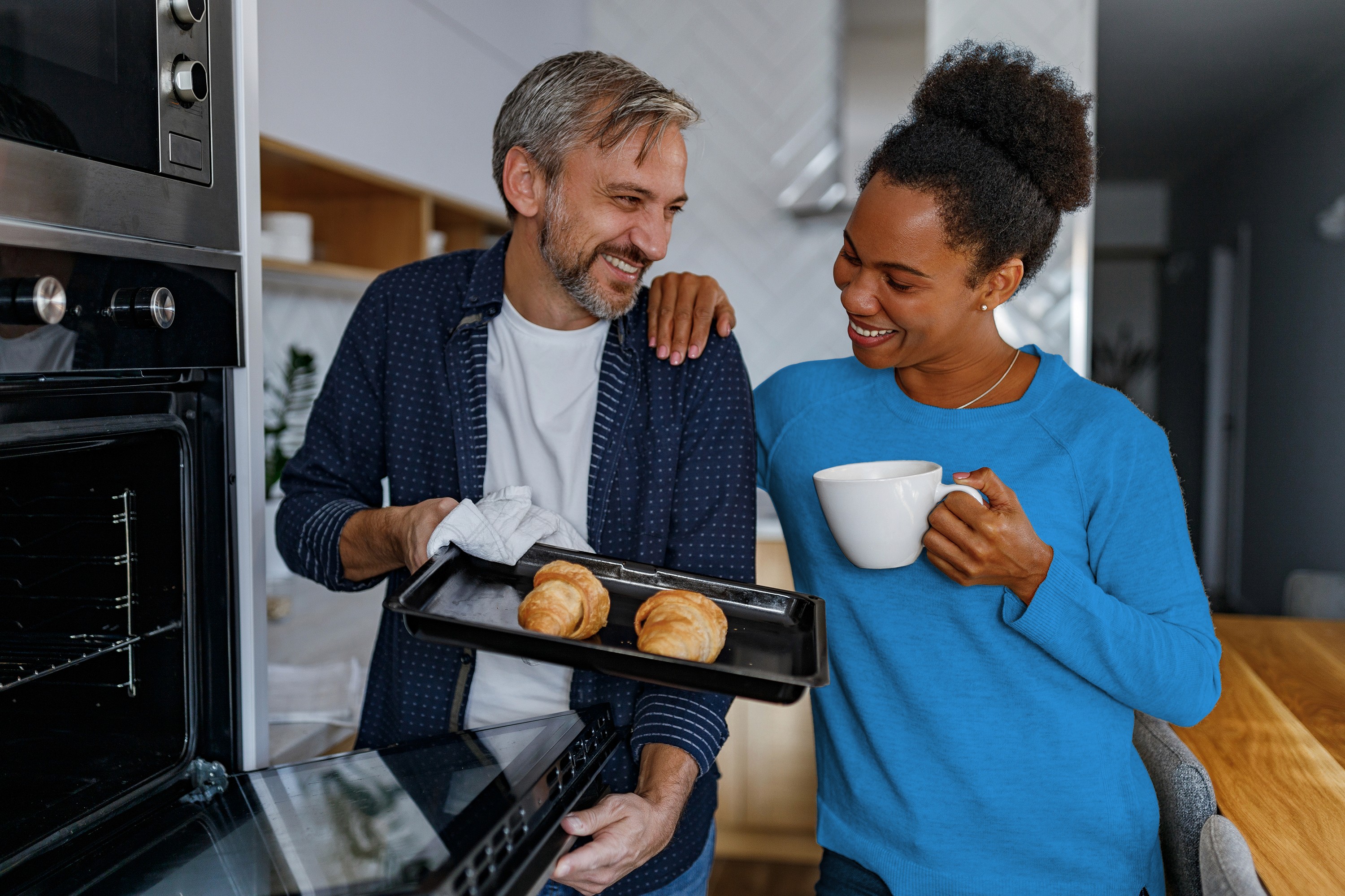 a couple making baked goods using an oven