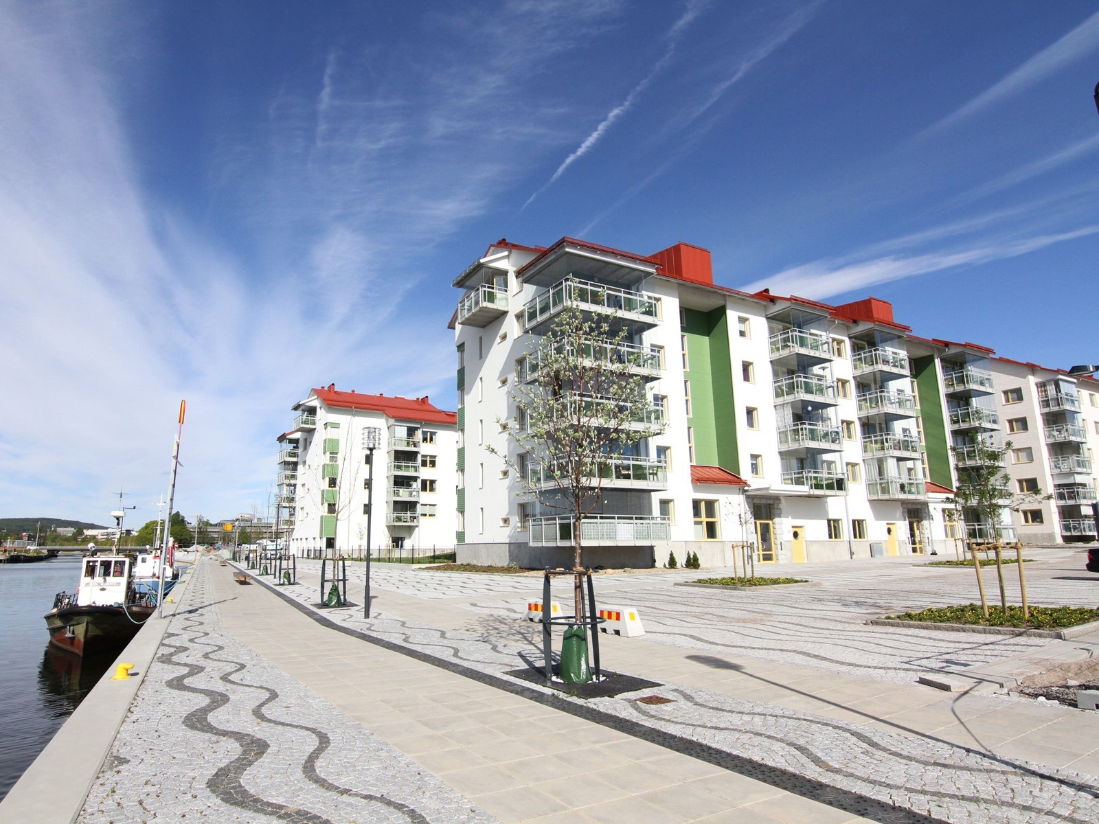 Edifício em construção com pavimentação concluída na frente.