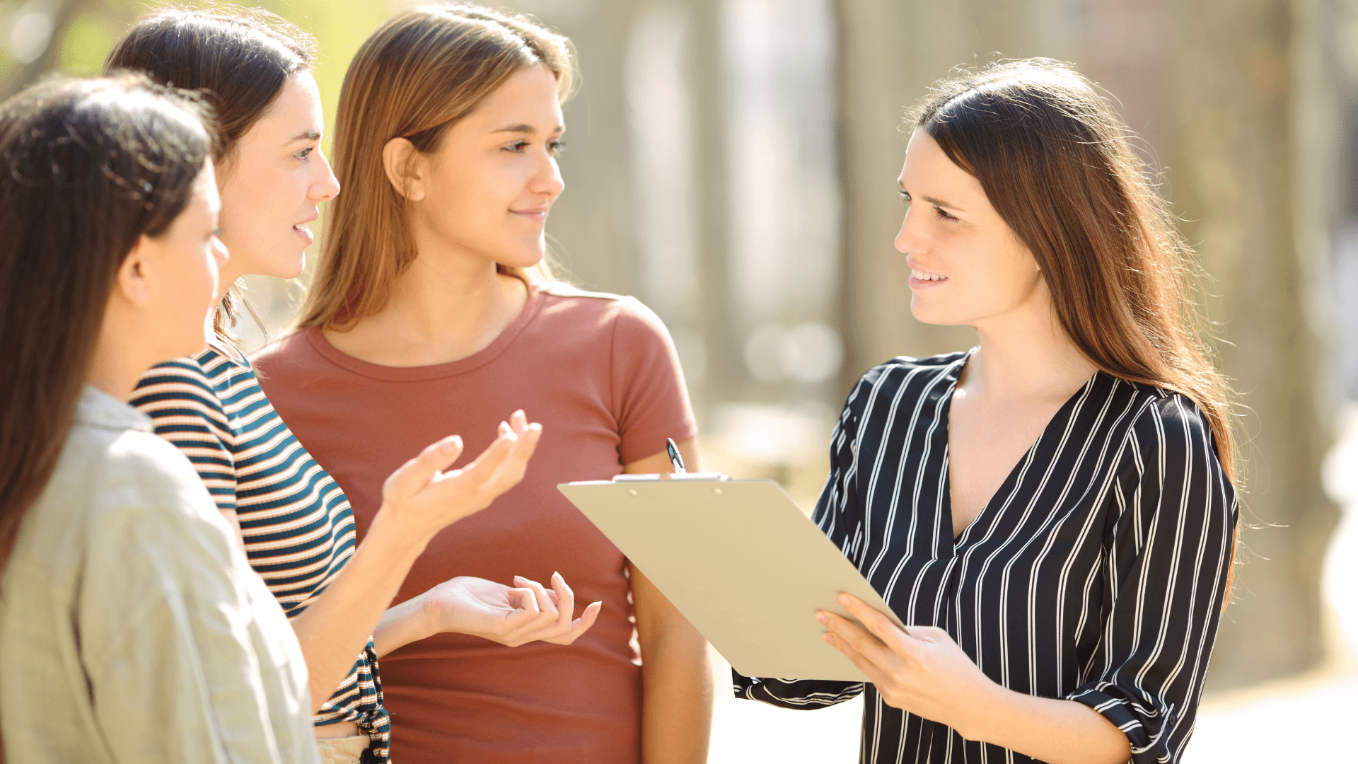 A woman with a clipboard asks several other women questions