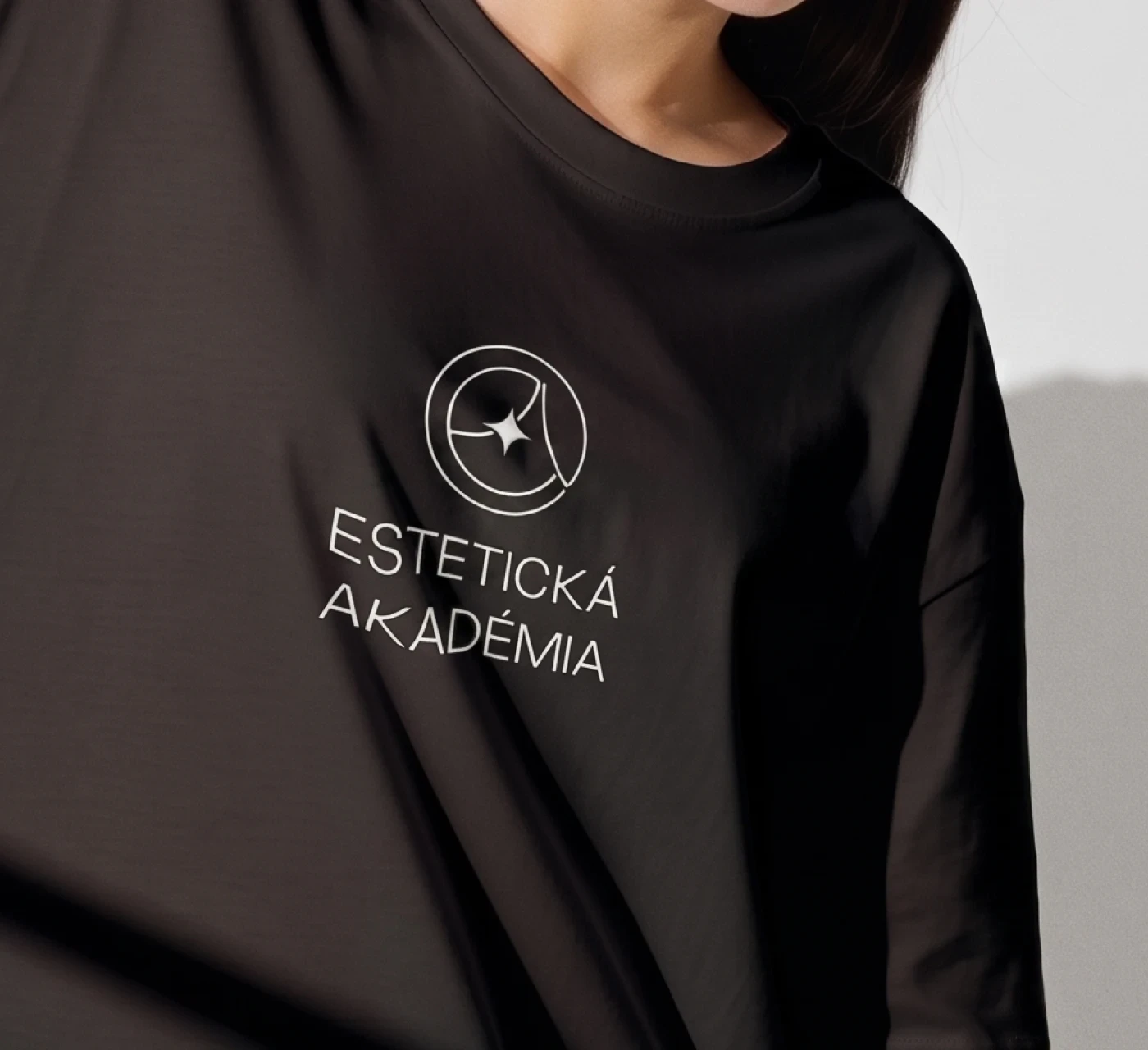 Black t-shirt with Estetická Akadémia chest logo print.