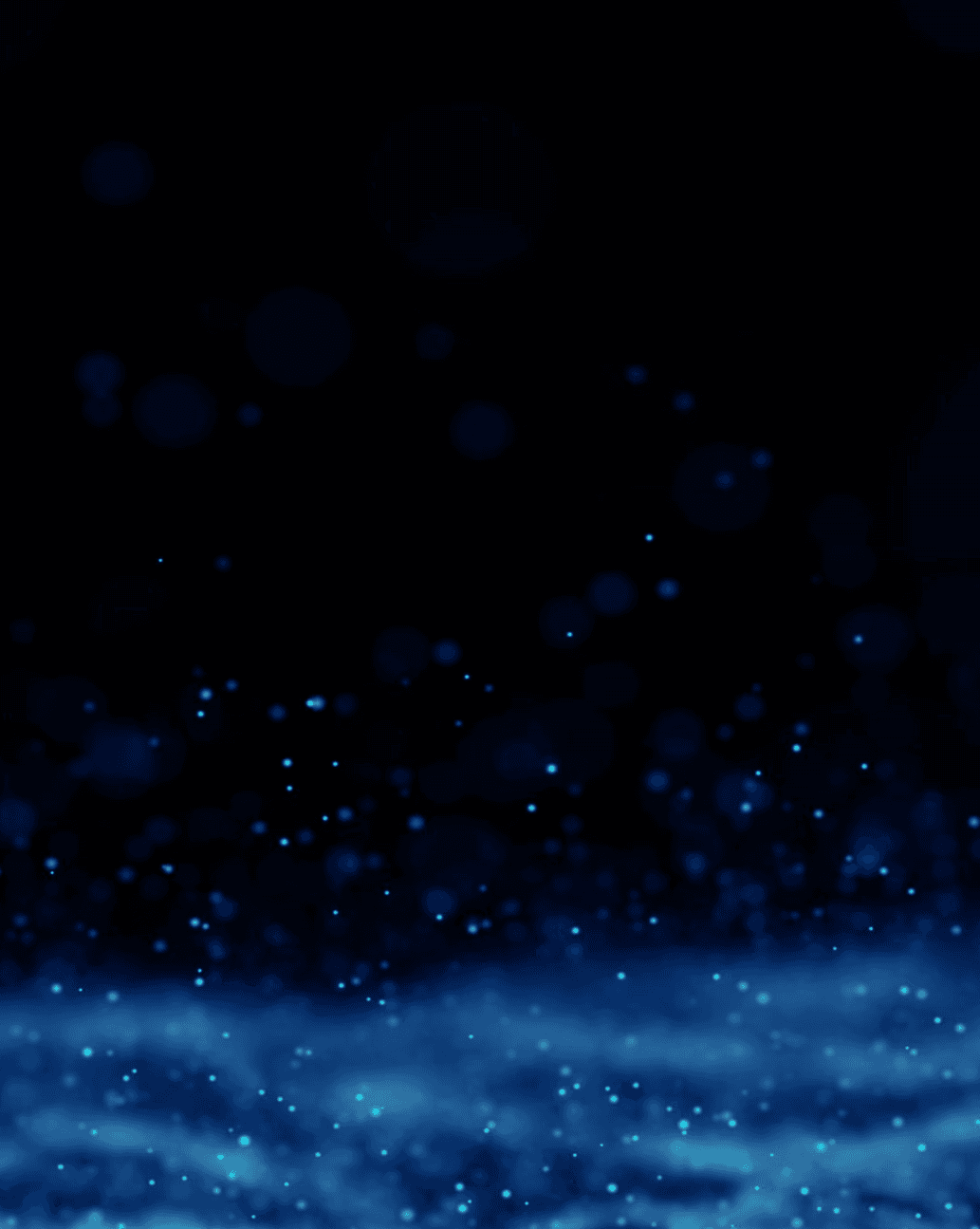 Close-up portrait of a person wearing a gray insulated hooded jacket with the hood up, showing their face framed by the hood against a light background.