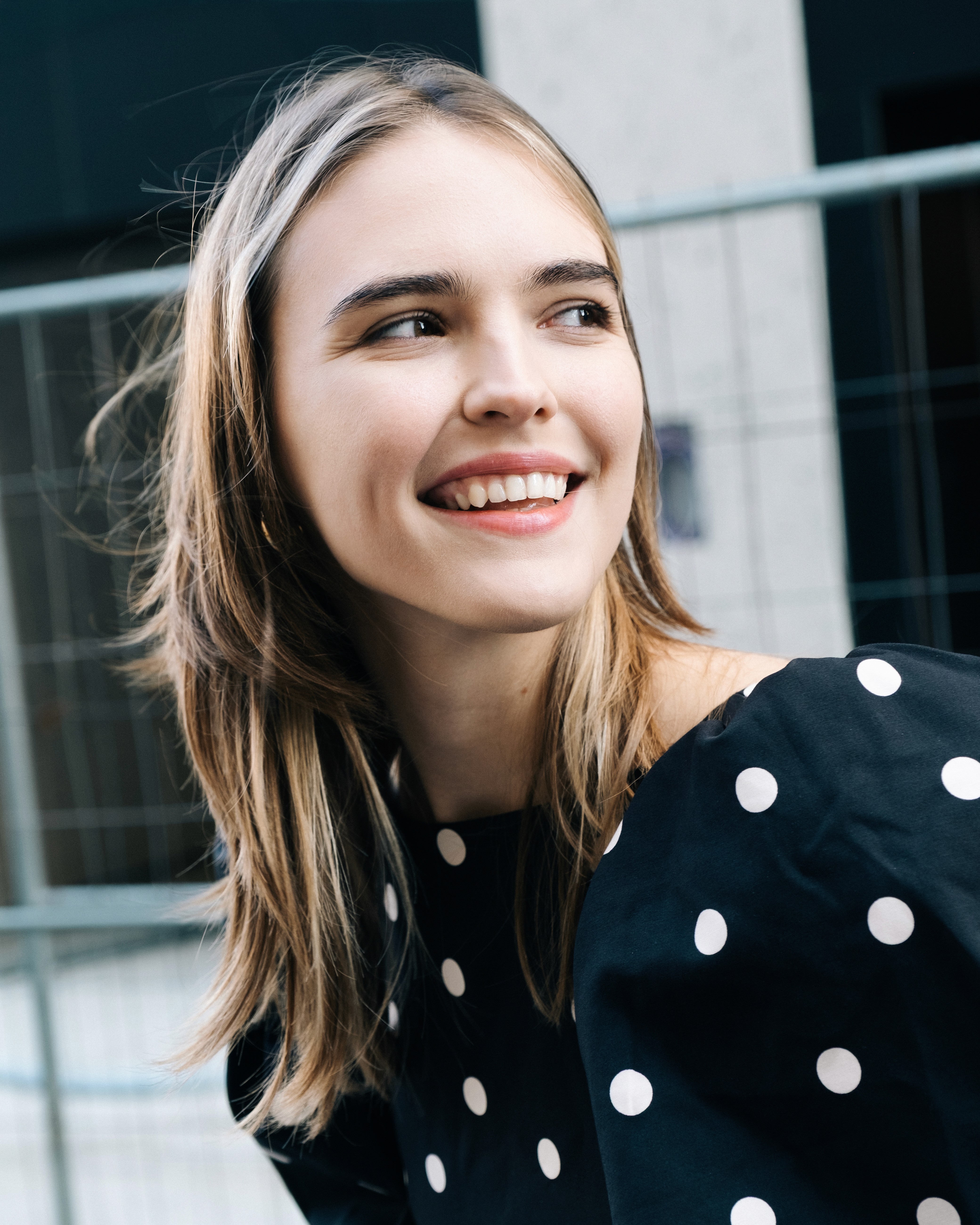 Ania – She Owns the City - smiling portrait in urban surroundings.