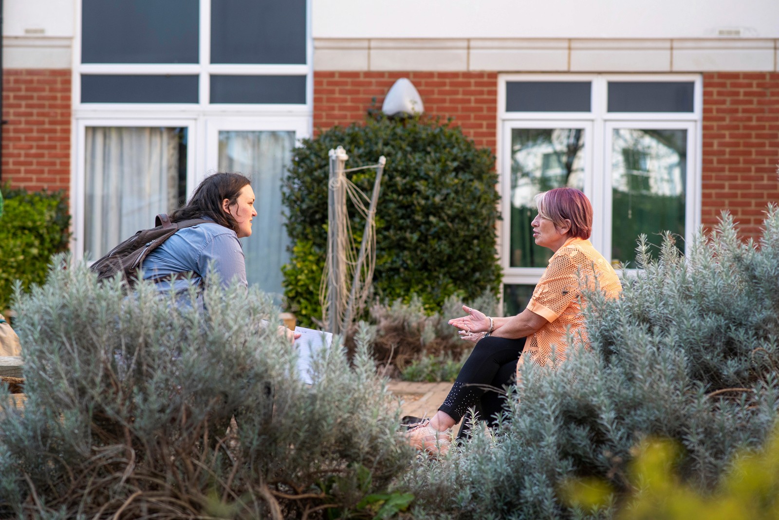Two people sitting in a home environment applying for carer´s allowance