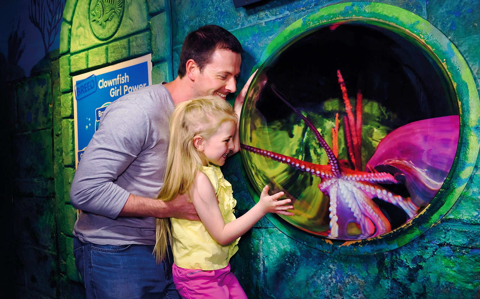 Family enjoying octopus exhibit at Sea Life London Aquarium.