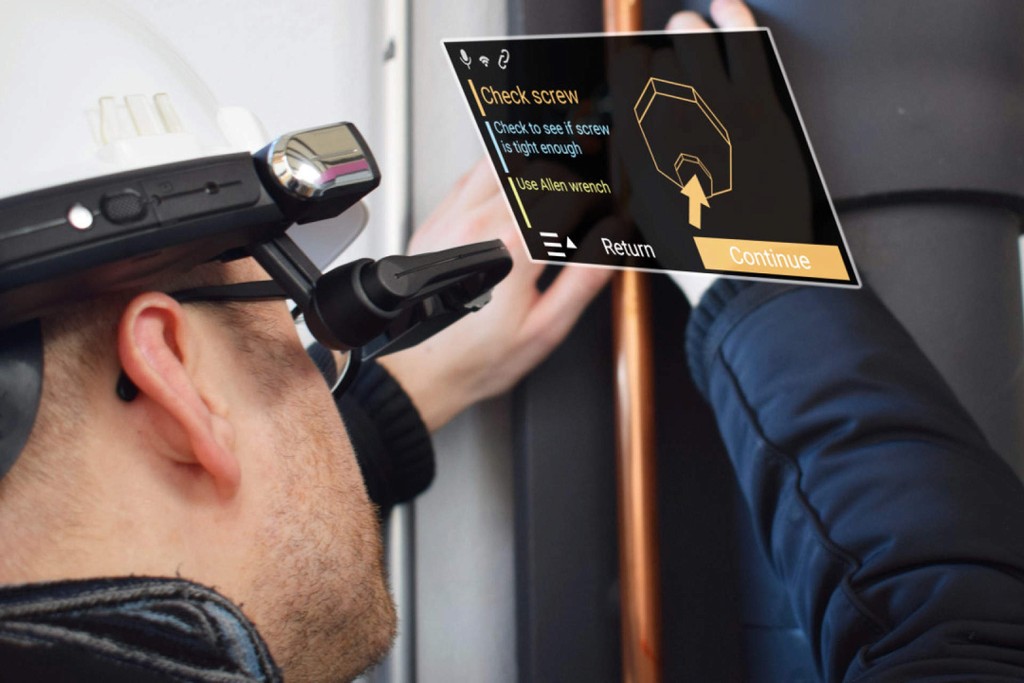 A photo of an industrial engineer wearing a RealWear headset and working on some equipment with augmented reality support helping him do his task