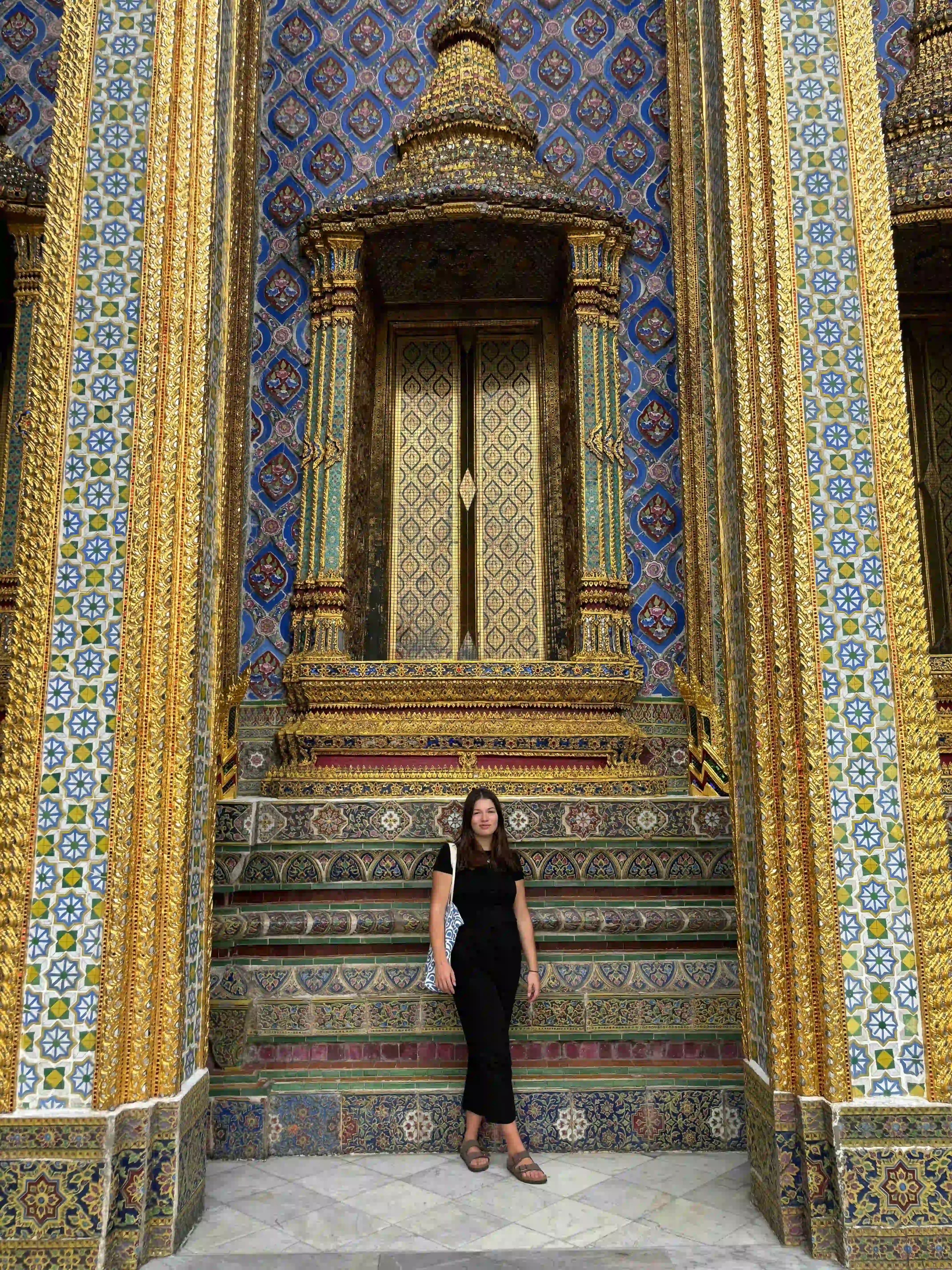 vrouw voor kleurrijk mozaïek van tempel in bangkok