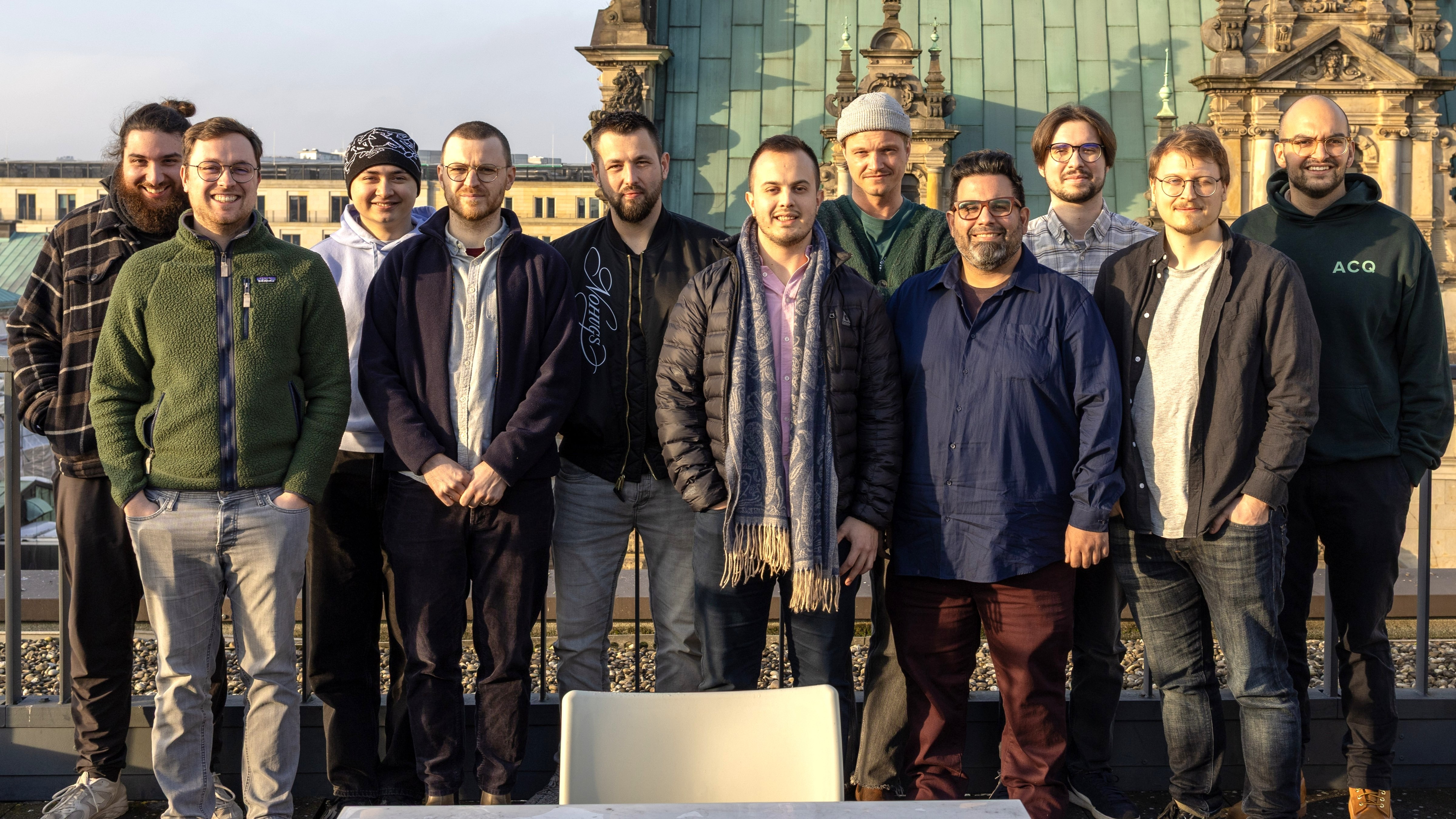 Teamfoto von den Mitarbeitern der Firma Indicium lächelnd vor einem historischem Gebäude