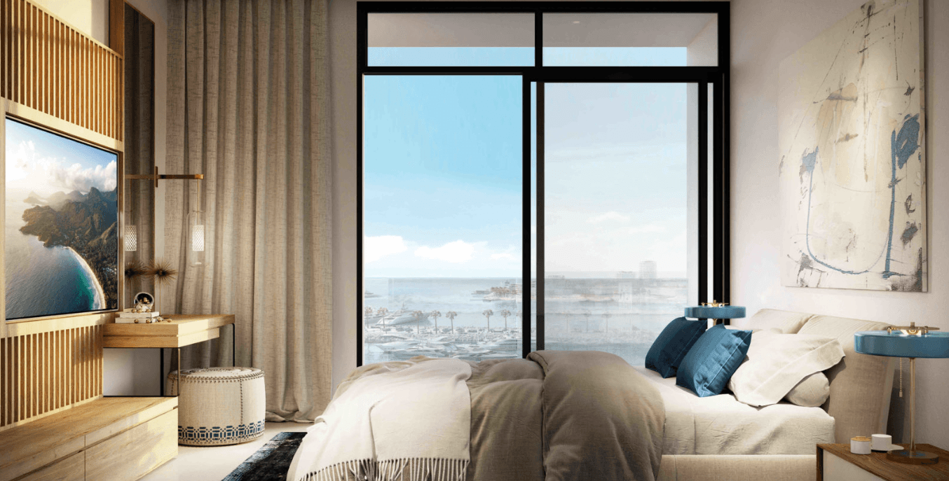 A serene bedroom featuring a large window with a view of the ocean, creating a tranquil seaside atmosphere.