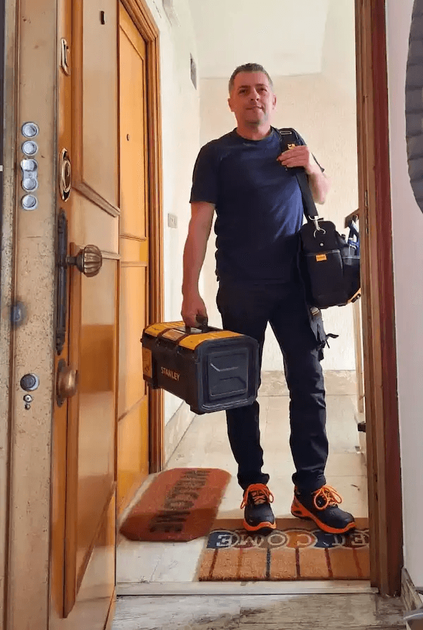 Titolare della S.A.Multiservizi Roma davanti appartamento con strumentazione tecnica e certificati