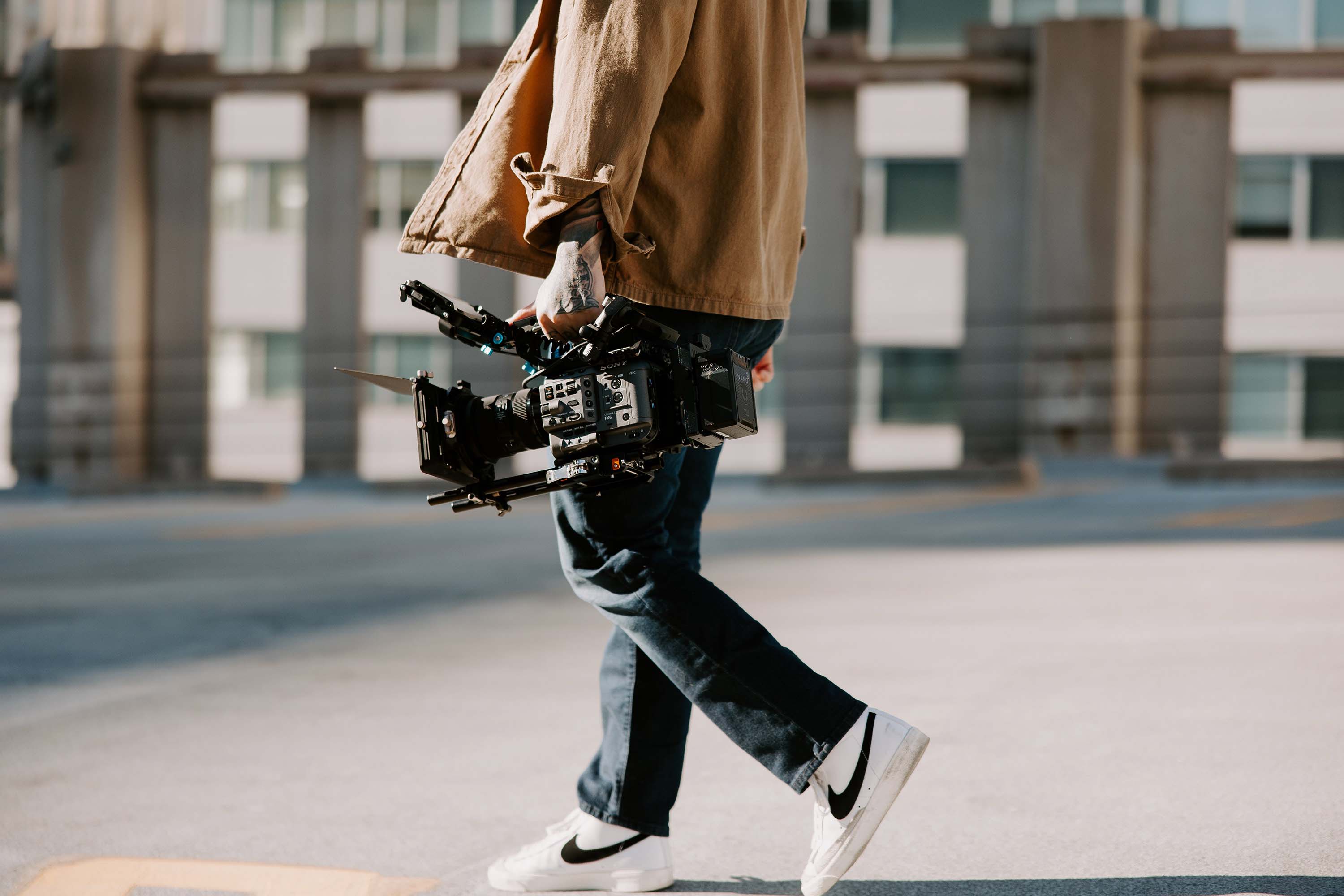 Jason Luong walking with a fully rigged out Sony FX6