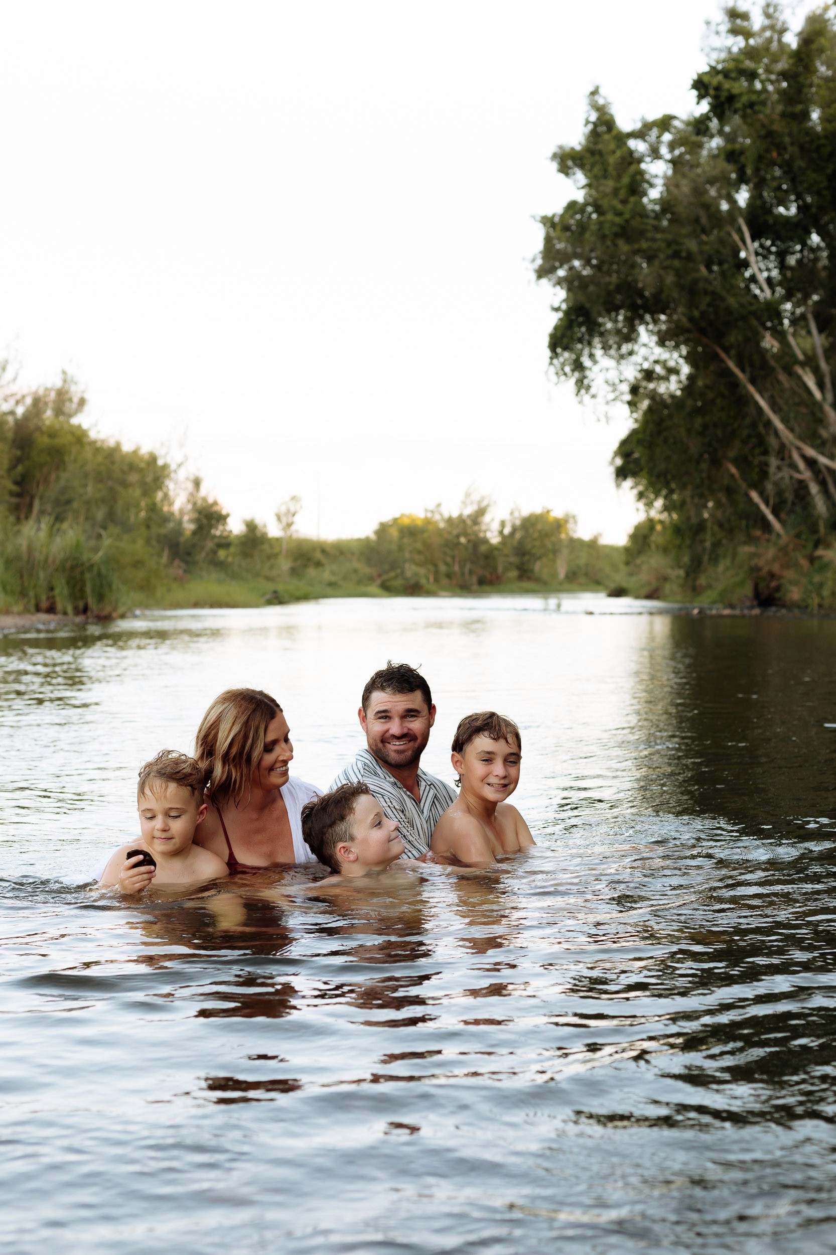 Family enjoying swim in water at photoshoot near Mackay