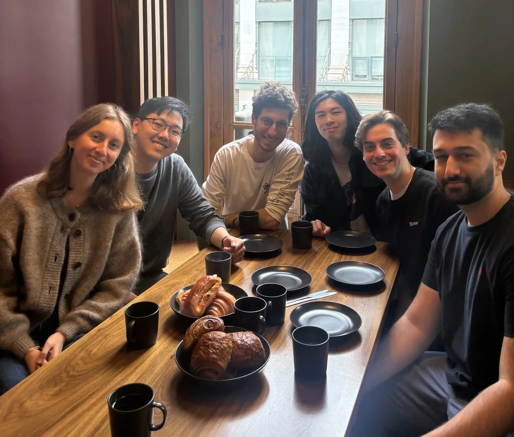 employee group dinner for uncovr ai, there is plates and cups on a wooden table
