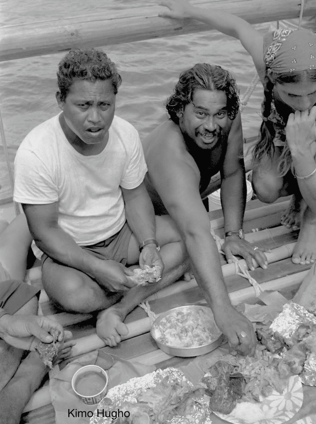 A hand wrapped in crinkled, translucent plastic reaches upwards against a dark background. The light highlights textures, evoking themes of entrapment and fragility.