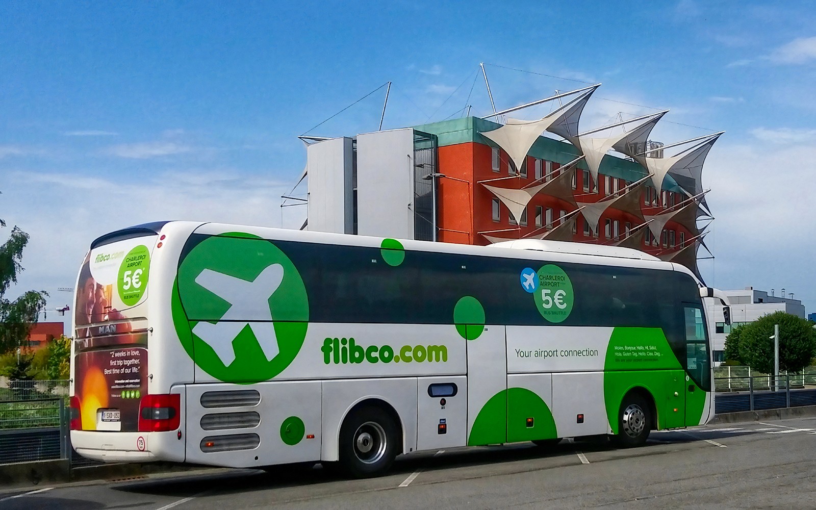 Shuttle bus for Charleroi Airport to Brussels route parked near modern building.