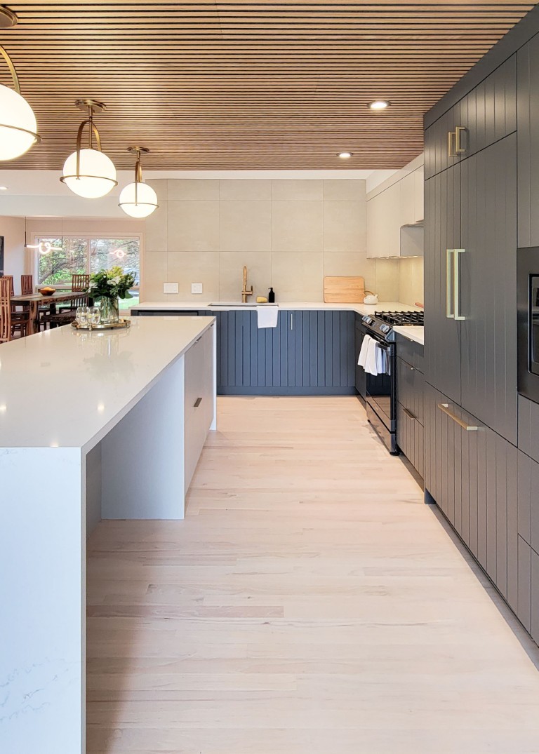 Image of Modern kitchen interior with island, gray cabinets, and white countertops designed by KHD Homes.