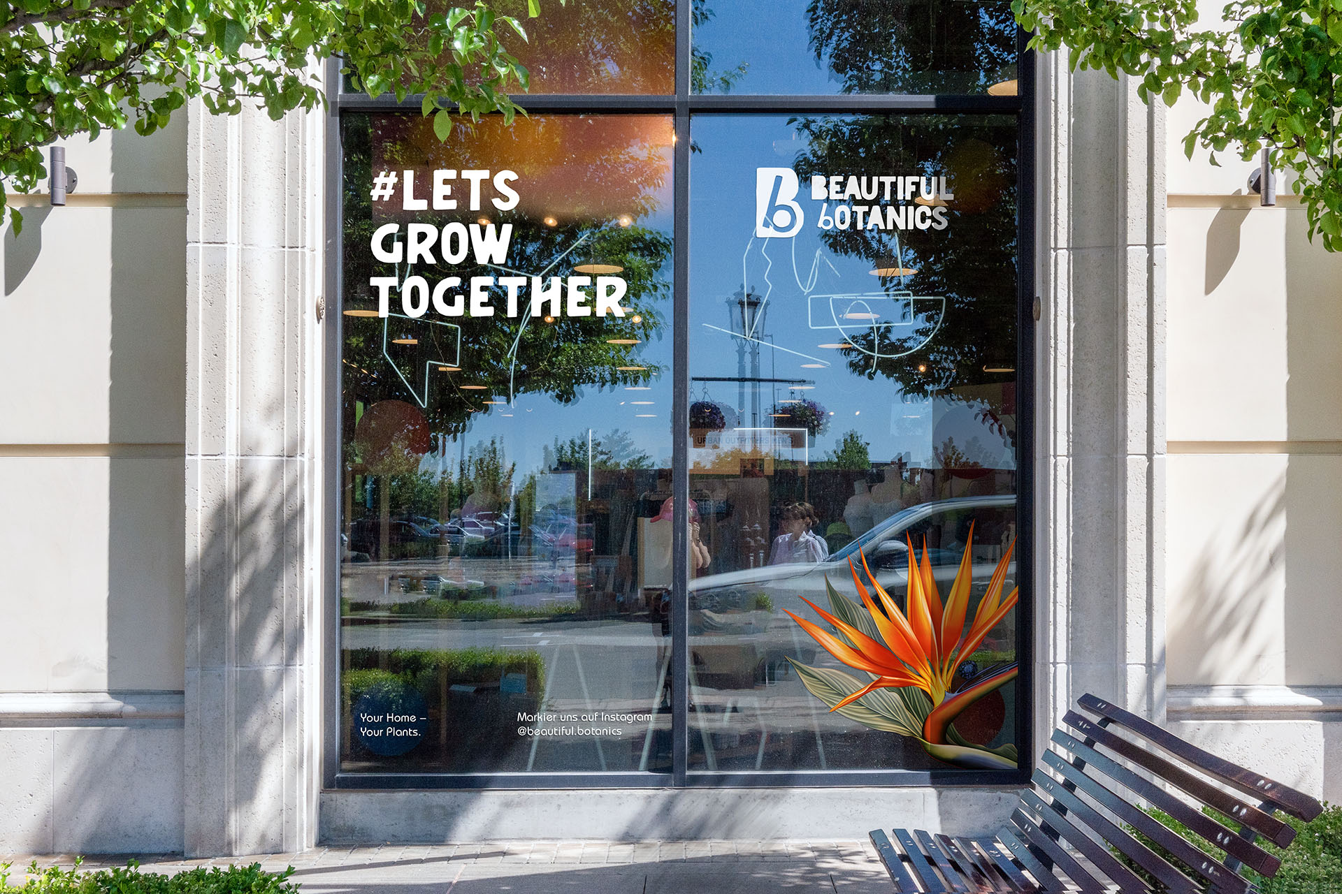 Fenster des Beautiful Botanics-Ladens mit gebrandetem Design und dem Schriftzug #LETSGROWTOGETHER in großen Buchstaben.
