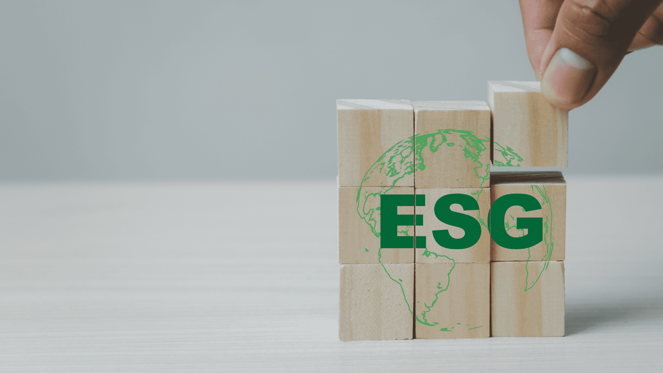 A man stands while two people sit at a table in an office setting, smiling and engaged in conversation. The mood is friendly and collaborative.