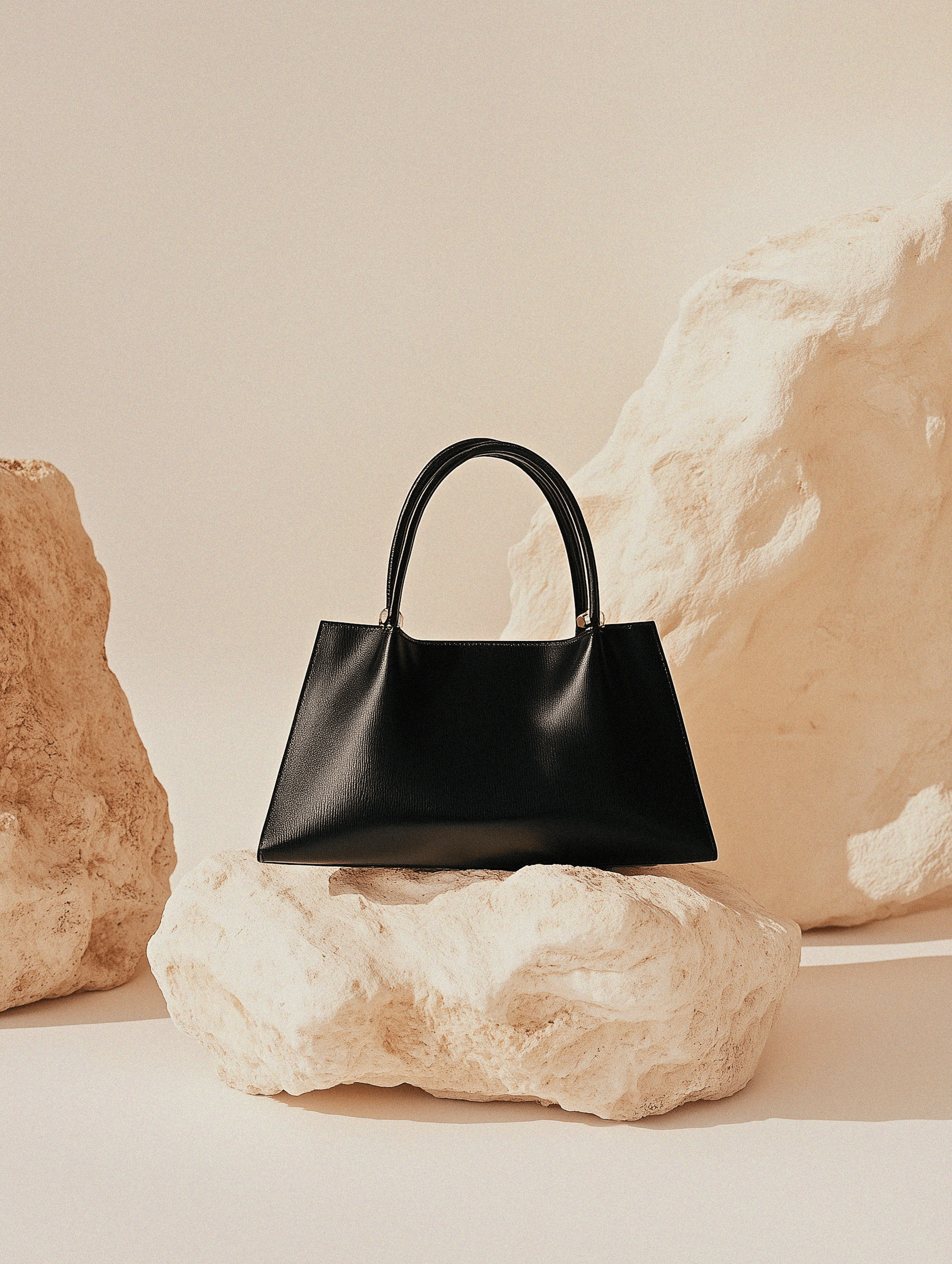 Black leather handbag on a rock.