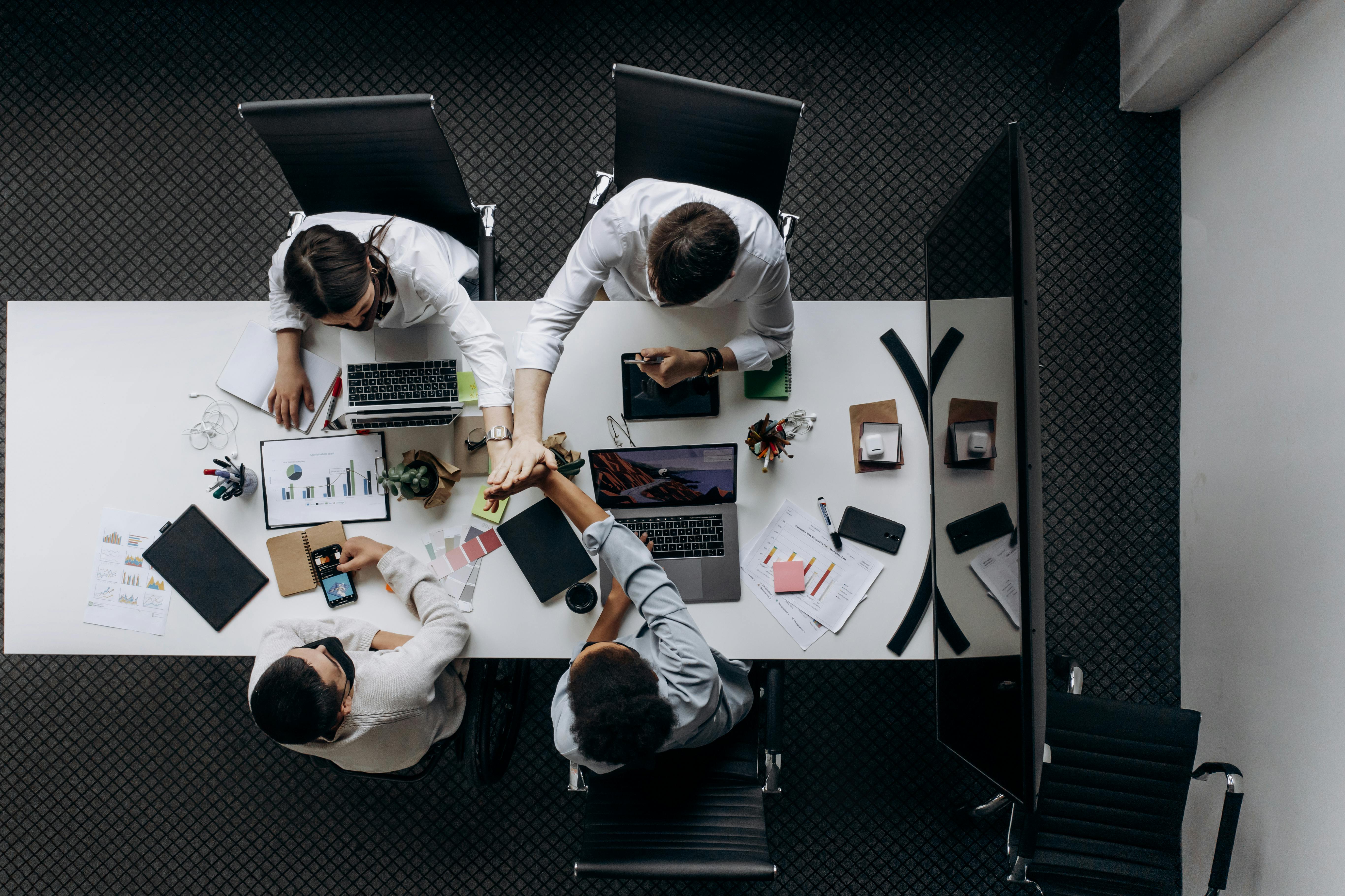 high-angle-view-of-colleagues-collaborating-around-a-conference-table-in-a-moder - mikhail-nilov (pexels)